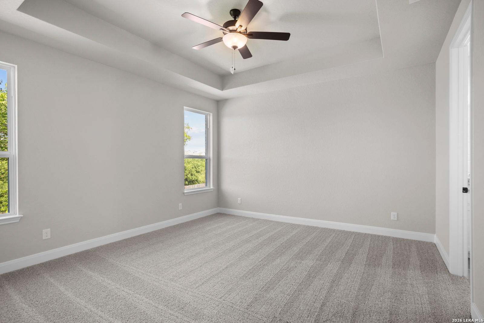 Spacious bedroom with tray ceiling and ceiling fan in The Jennings G floor plan by Davidson Homes in Ladera, San Antonio.