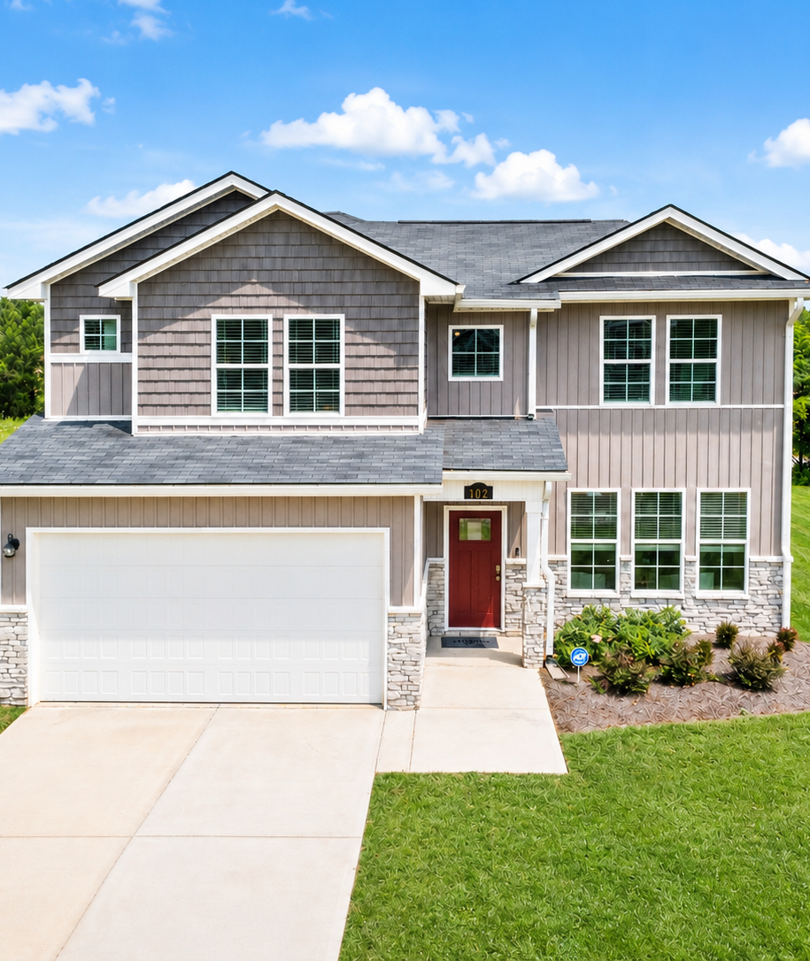 Two-story Davidson Homes exterior at Ivy Glen in Perry, Georgia, featuring gray siding, stone accents, and a red front door.