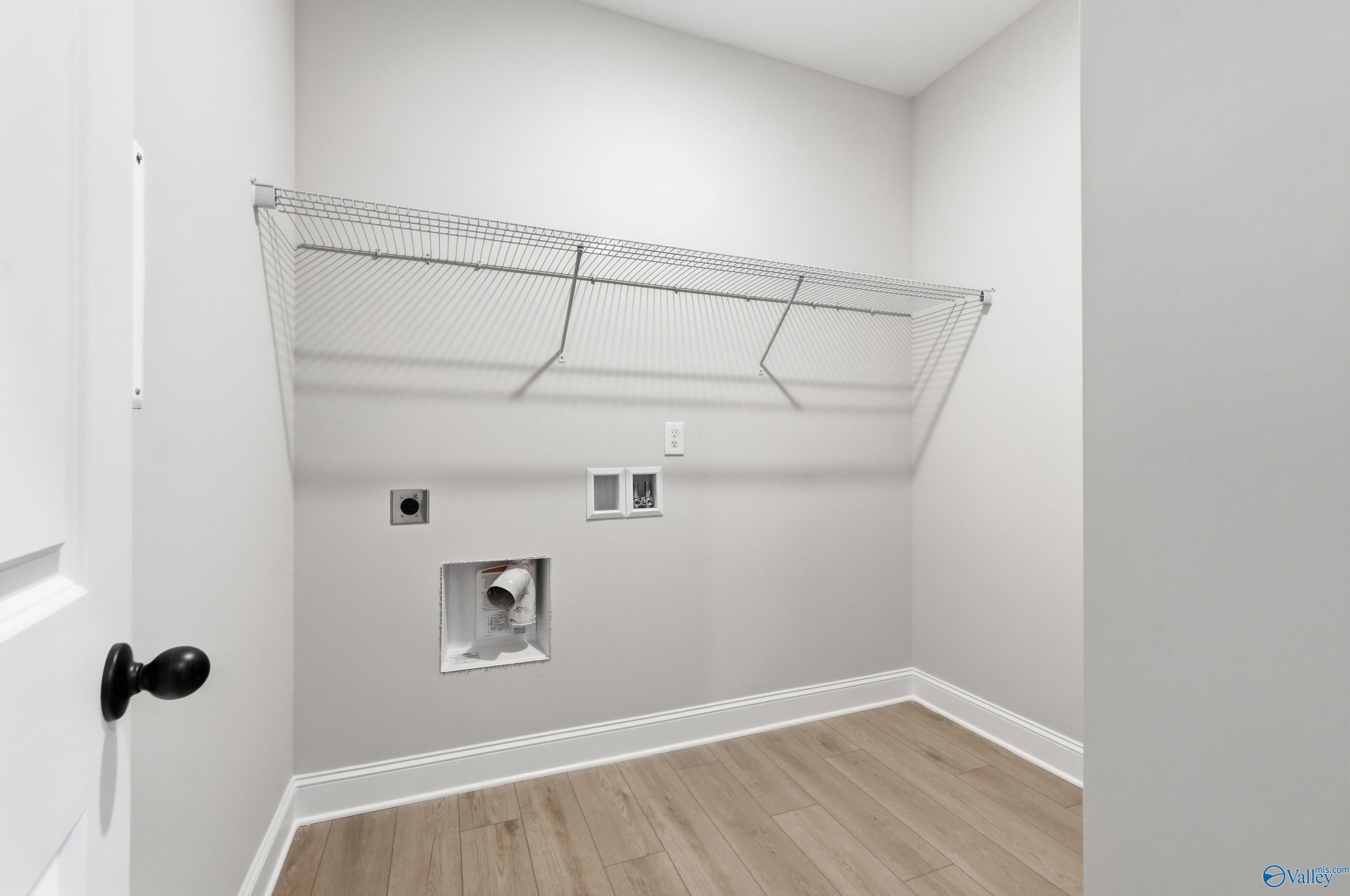 Bright laundry room with wire shelving and washer/dryer hookups in Davidson Homes The Daphne C, Athens, Alabama