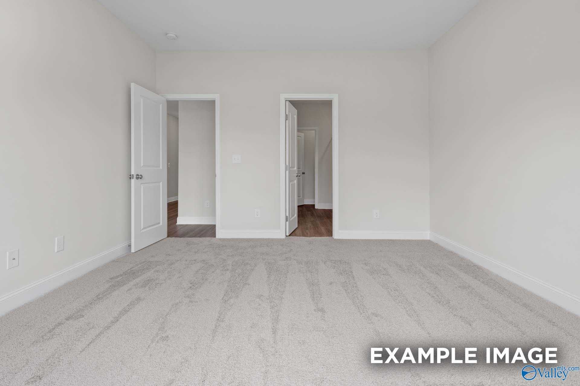 Empty secondary bedroom with open doors to bathroom and closet in 4-bedroom The Daphne D home, Davidson Homes, Arab, Alabama