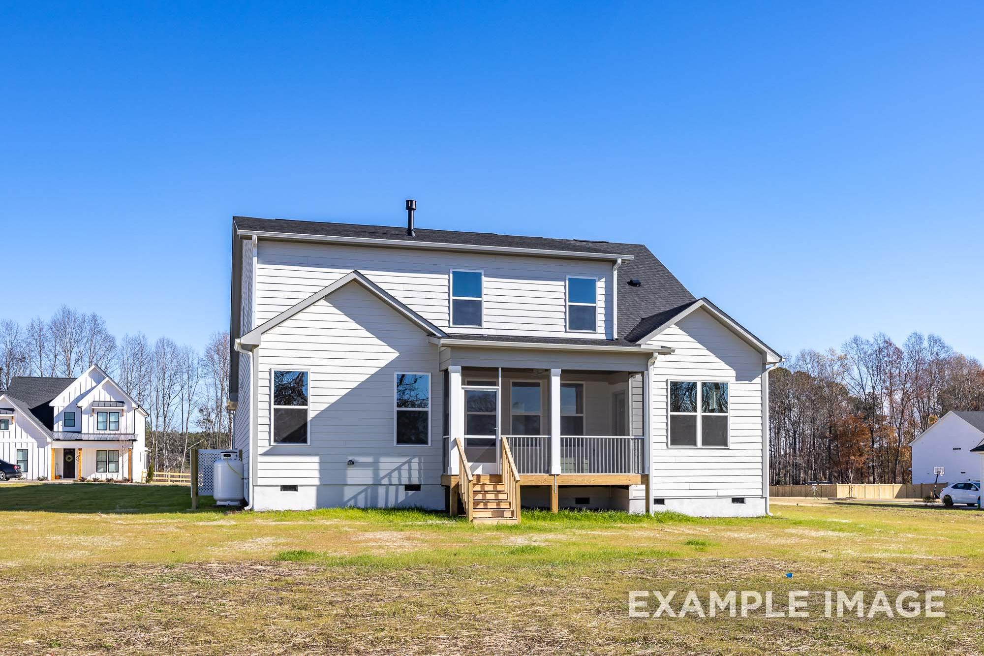 Rear elevation of The Cypress C II two-story home with covered porch, white siding, and upper master suite windows in Angier, NC