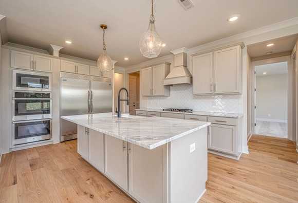 Davidson Homes The Hawkins Floor Plan Kitchen with light gray cabinets and marble countertops with appliances