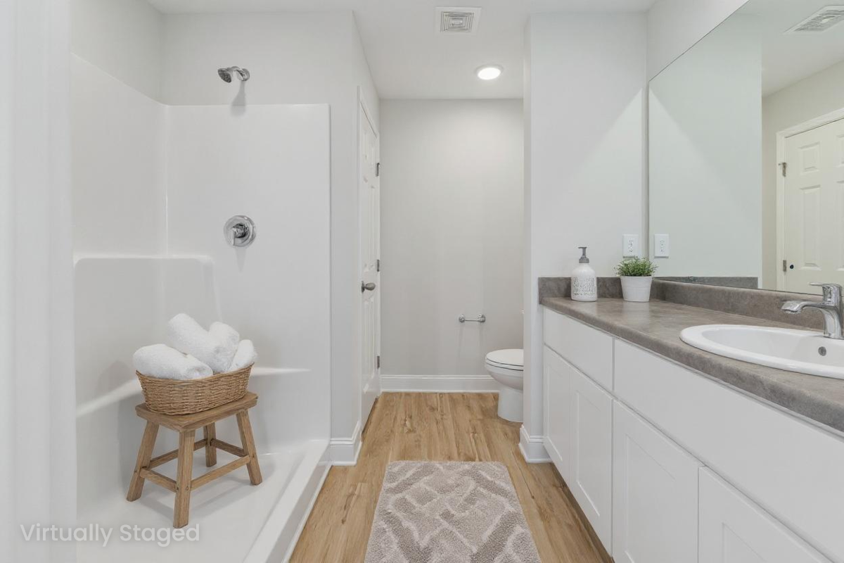 Modern white bathroom at Chapel Hill in Athens Alabama with walk-in shower, double vanity, hardwood floors
