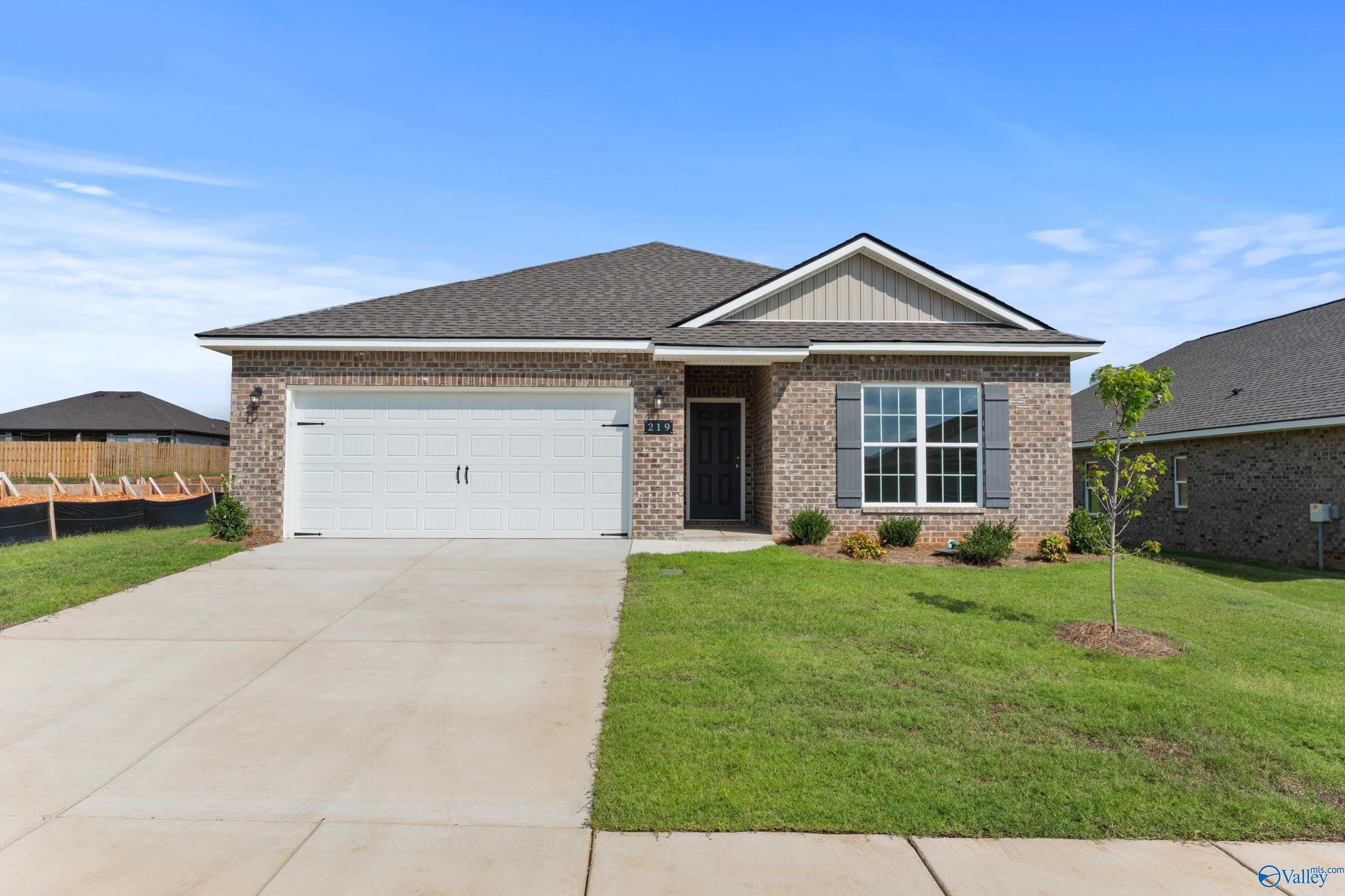 Modern 1-story brick ranch home with 2-car garage, driveway, and lush lawn in Wood Trail, Toney, Alabama - Davidson Homes The Franklin C