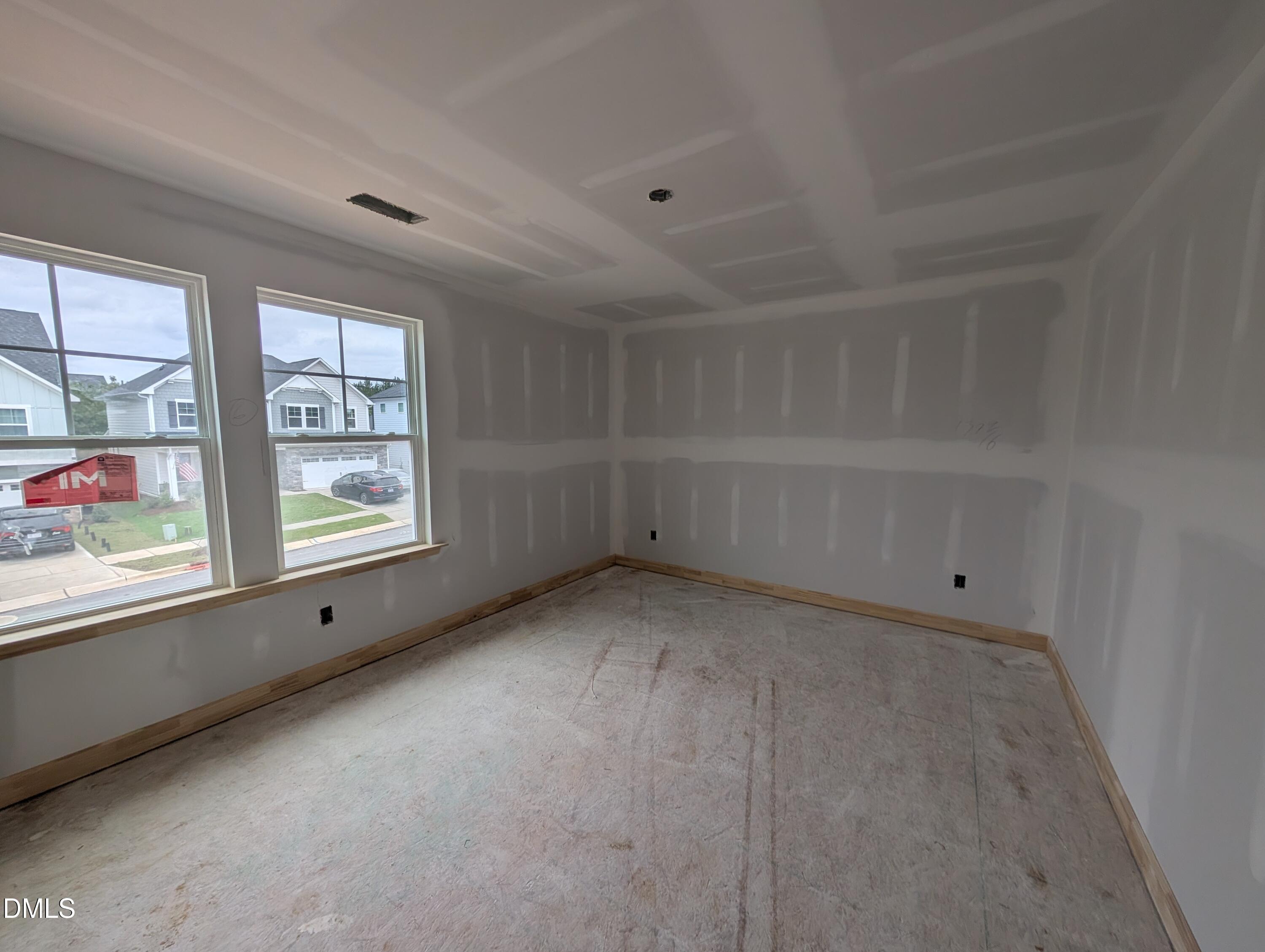Unfinished bedroom with double windows and coffered ceiling in Davidson Homes The Beech plan at Wendell Ridge, Wendell, NC