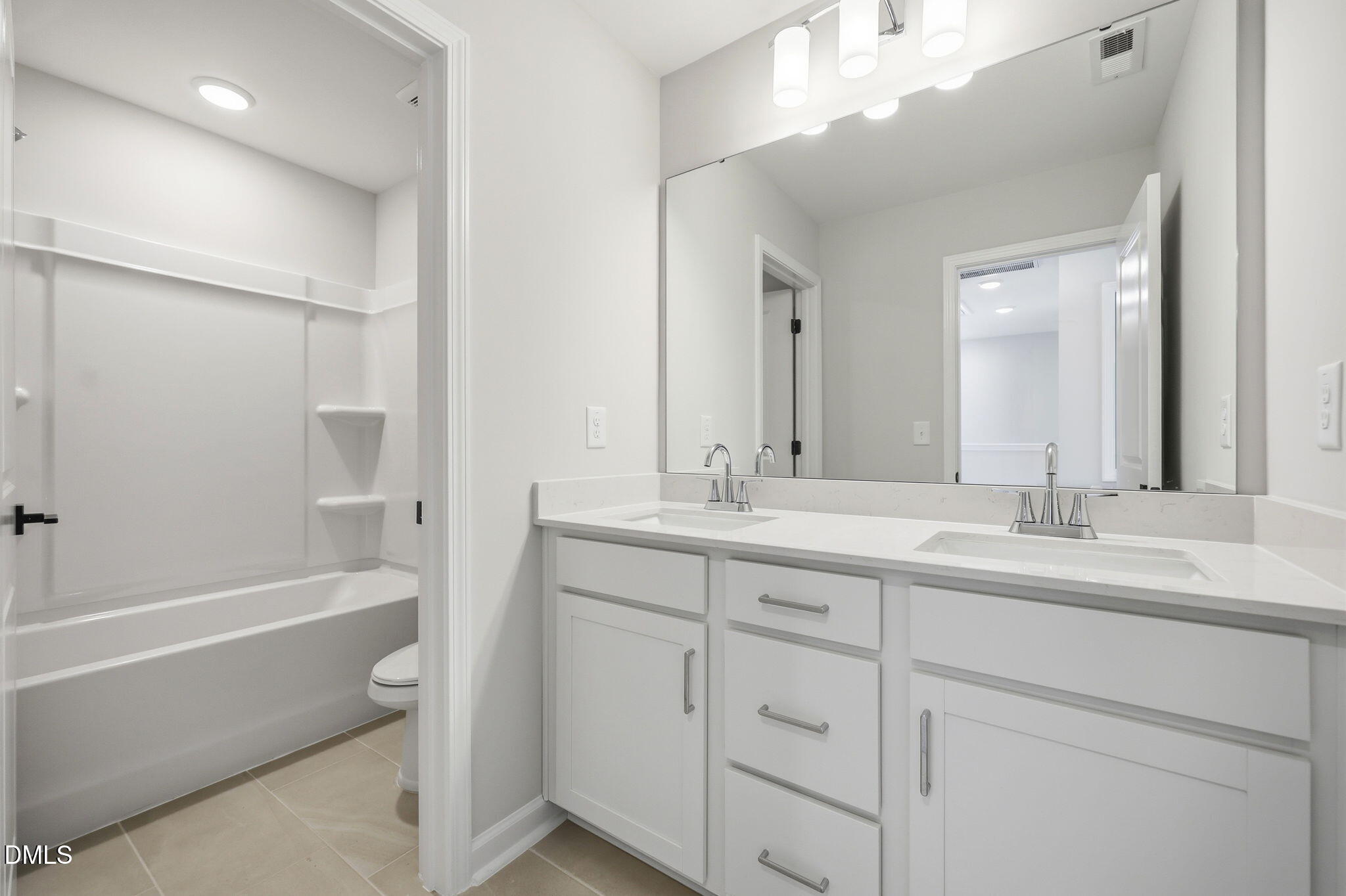 Modern bathroom with double vanity and tub-shower combo in The Avery floor plan at Forestville Yard Townhomes, Knightdale.