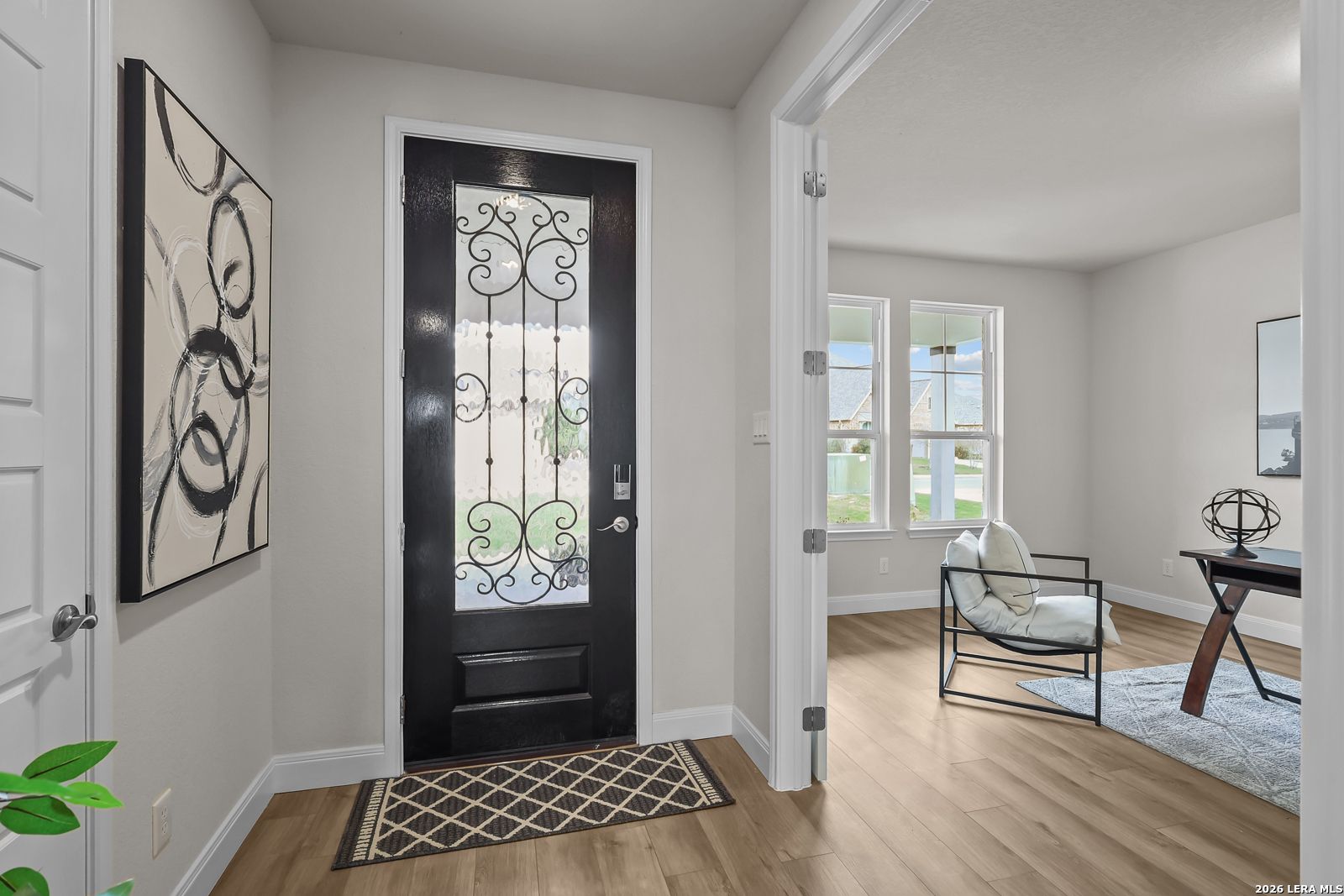 Elegant entryway with decorative black door and home office view in The Lanier H floor plan, Ladera, San Antonio, Texas.