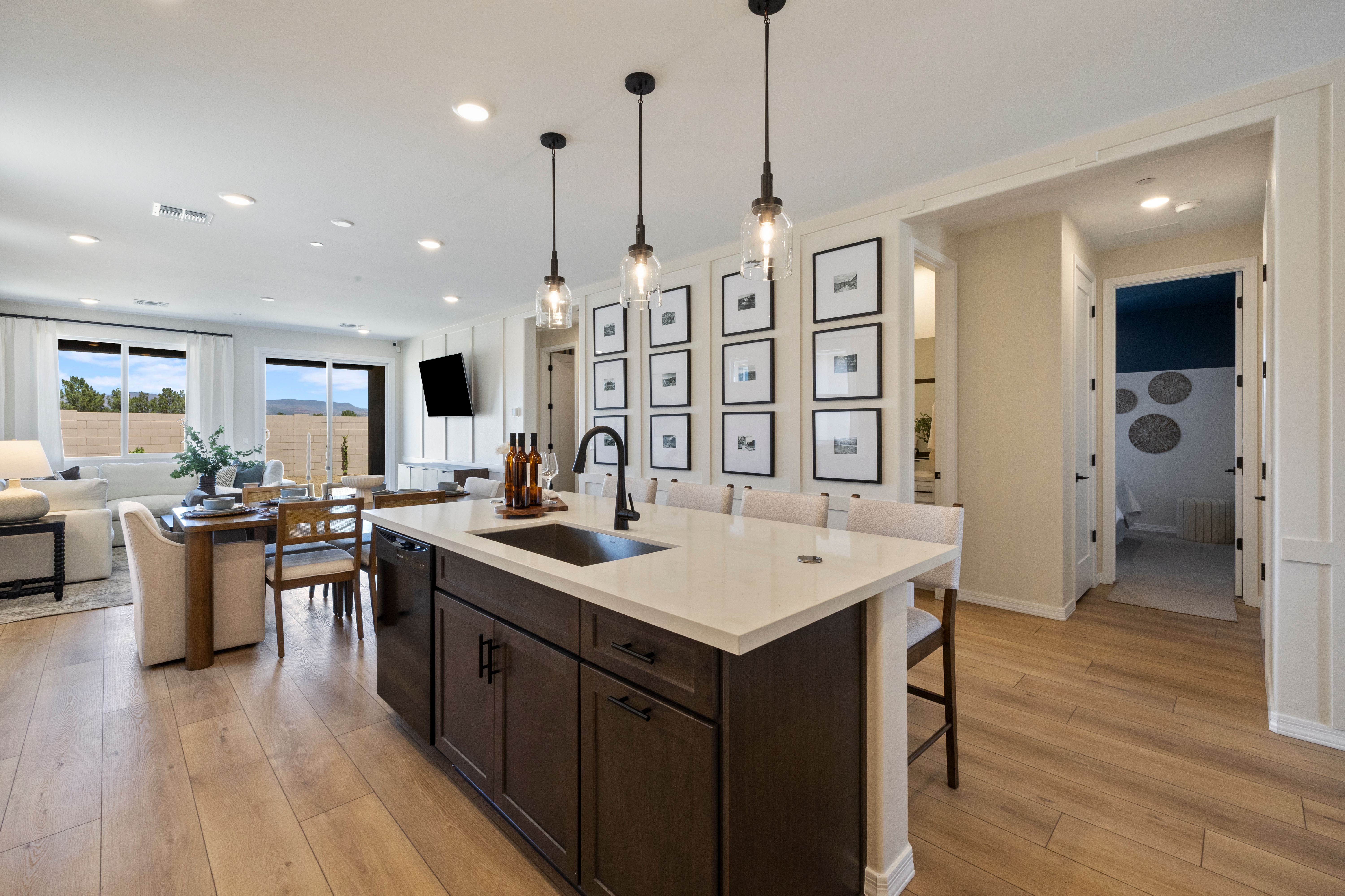 Open-concept kitchen at Vineyards at Cottonwood in Cottonwood AZ featuring white quartz island, dark cabinets, pendant lights, hardwood floors, and desert views