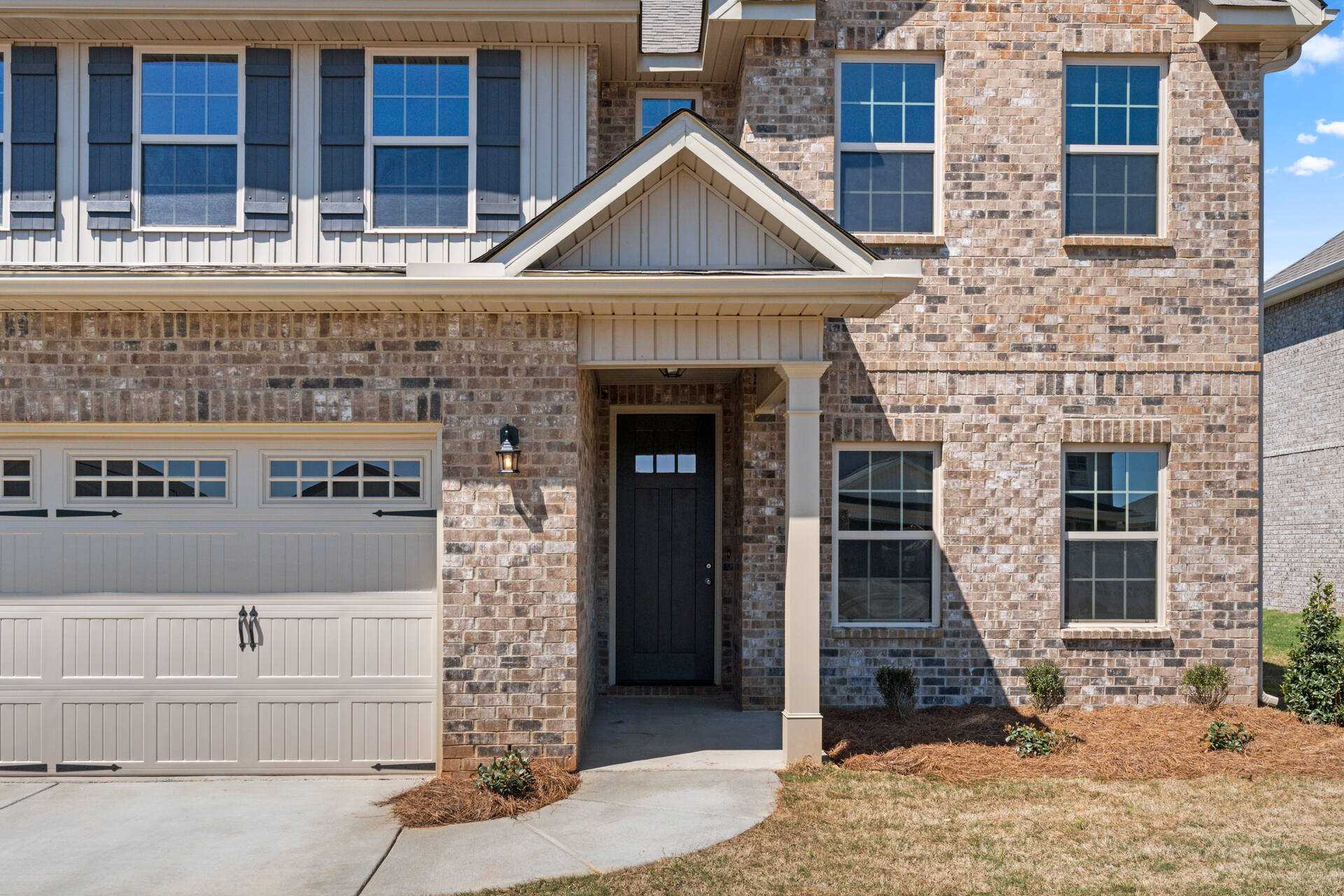 Modern brick home exterior at Little Burwell Estates in Harvest Alabama with covered porch and two-car garage