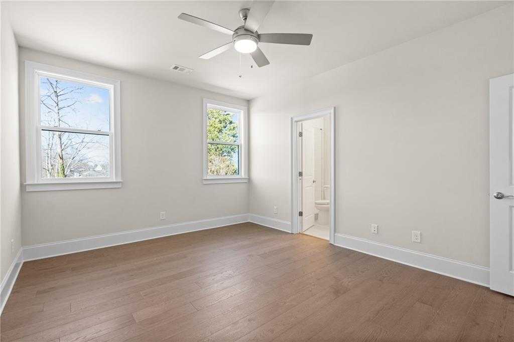 Bright secondary bedroom with hardwood floors, ceiling fan, and en-suite bath in Davidson Homes The Arlington A, East Cobb