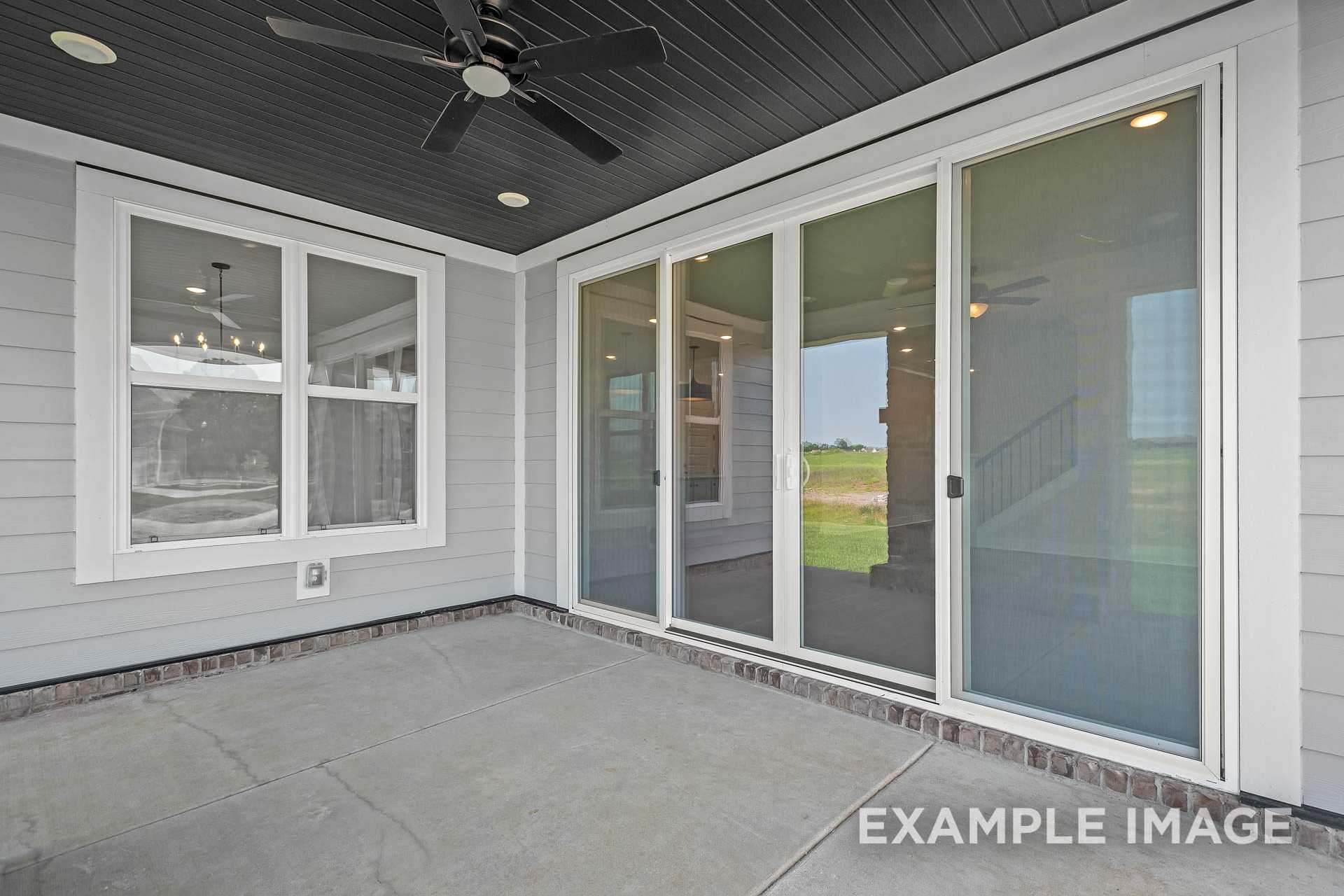 Covered patio in The Hathaway home design by Davidson Homes, featuring sliding glass doors, ceiling fan, and interior view in Murfreesboro