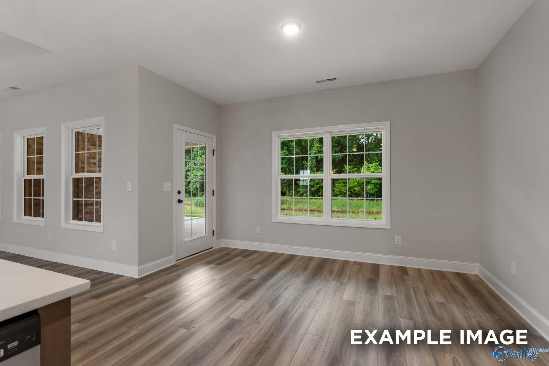 Bright living area with large windows, French door to patio, hardwood floors in Davidson Homes The Finleigh, Meridianville, Alabama