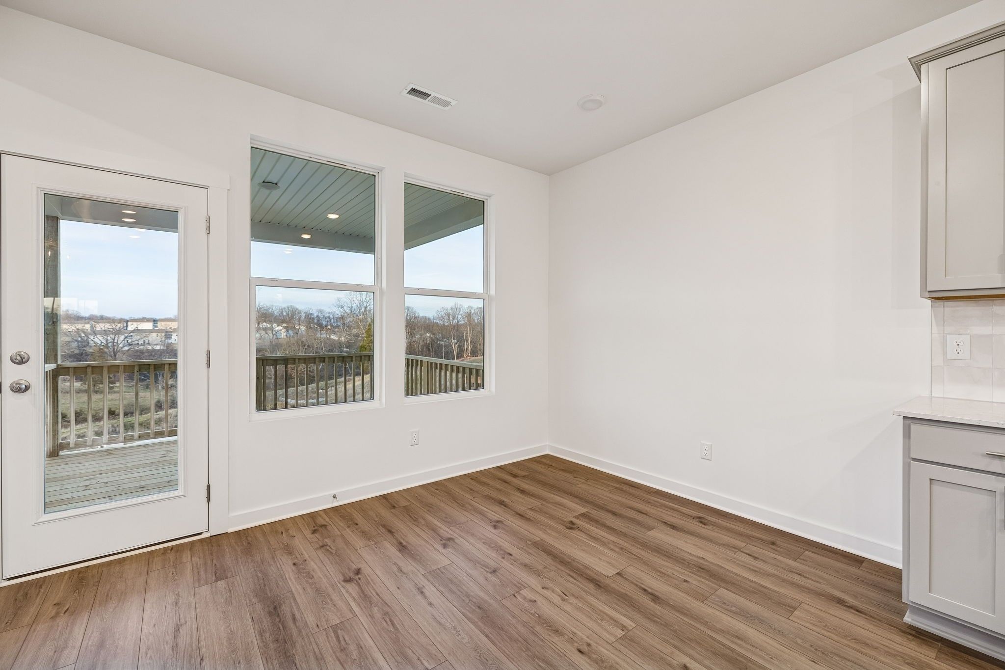 Bright breakfast nook with white cabinets, hardwood floors, and deck views in Davidson Homes The Willow, White House, TN