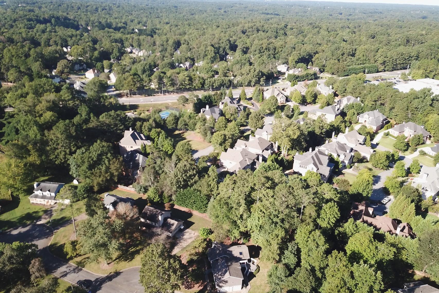 Aerial view of Tanglewood neighborhood in East Cobb Georgia with homes nestled in lush forests and blue community pool