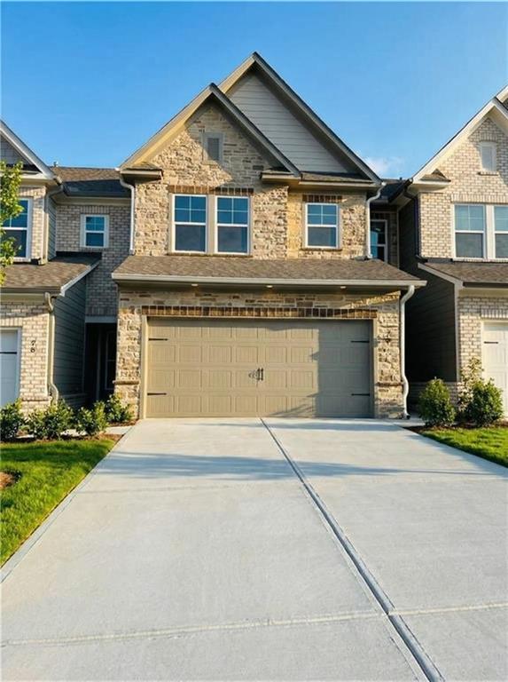 Modern 2-story Cary C home exterior by Davidson Homes with stone accents, 2-car garage, driveway in Lake Shore, Winder, Georgia