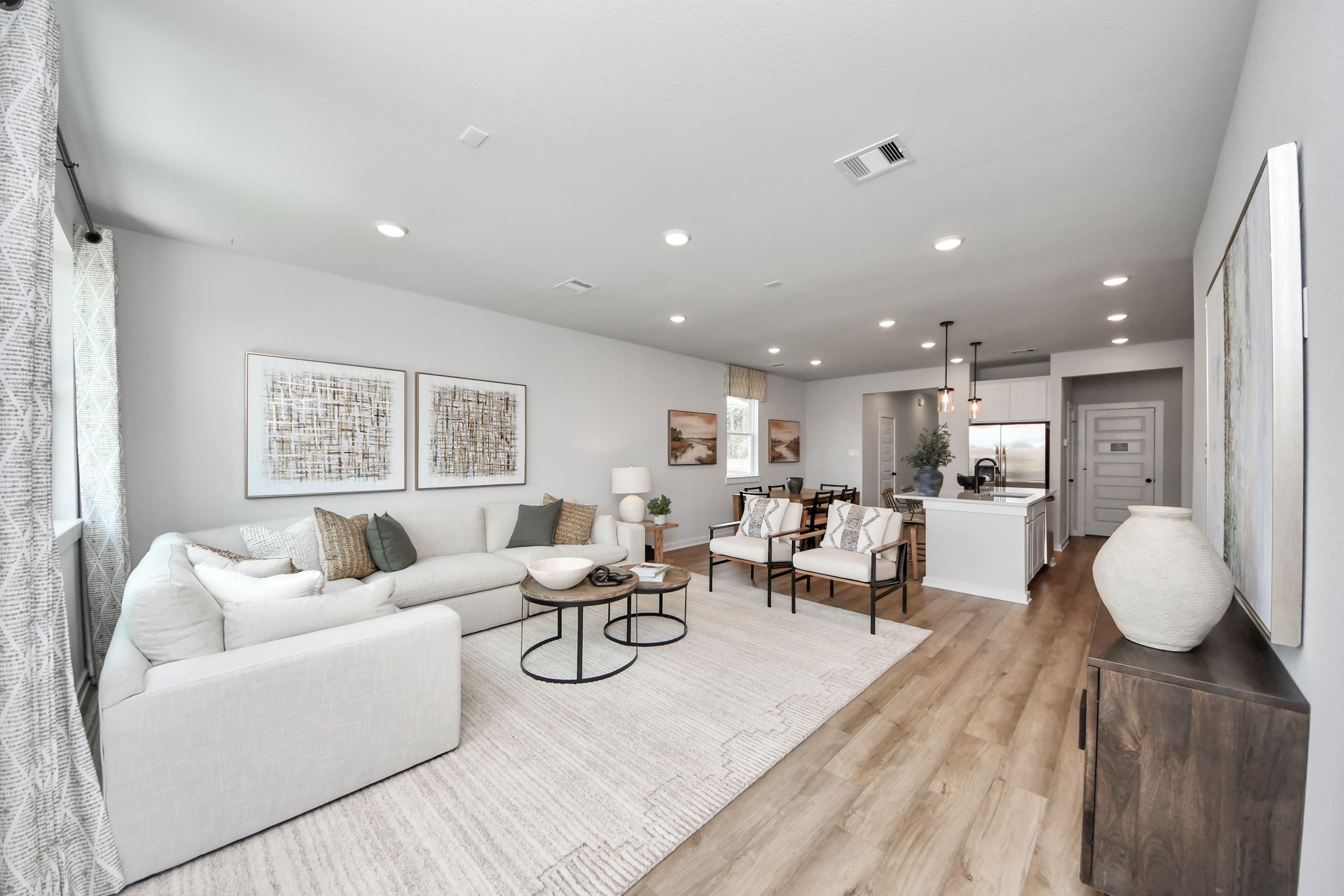 Open-concept living room at Robins Landing in Houston by Davidson Homes, featuring modern furniture and hardwood floors.