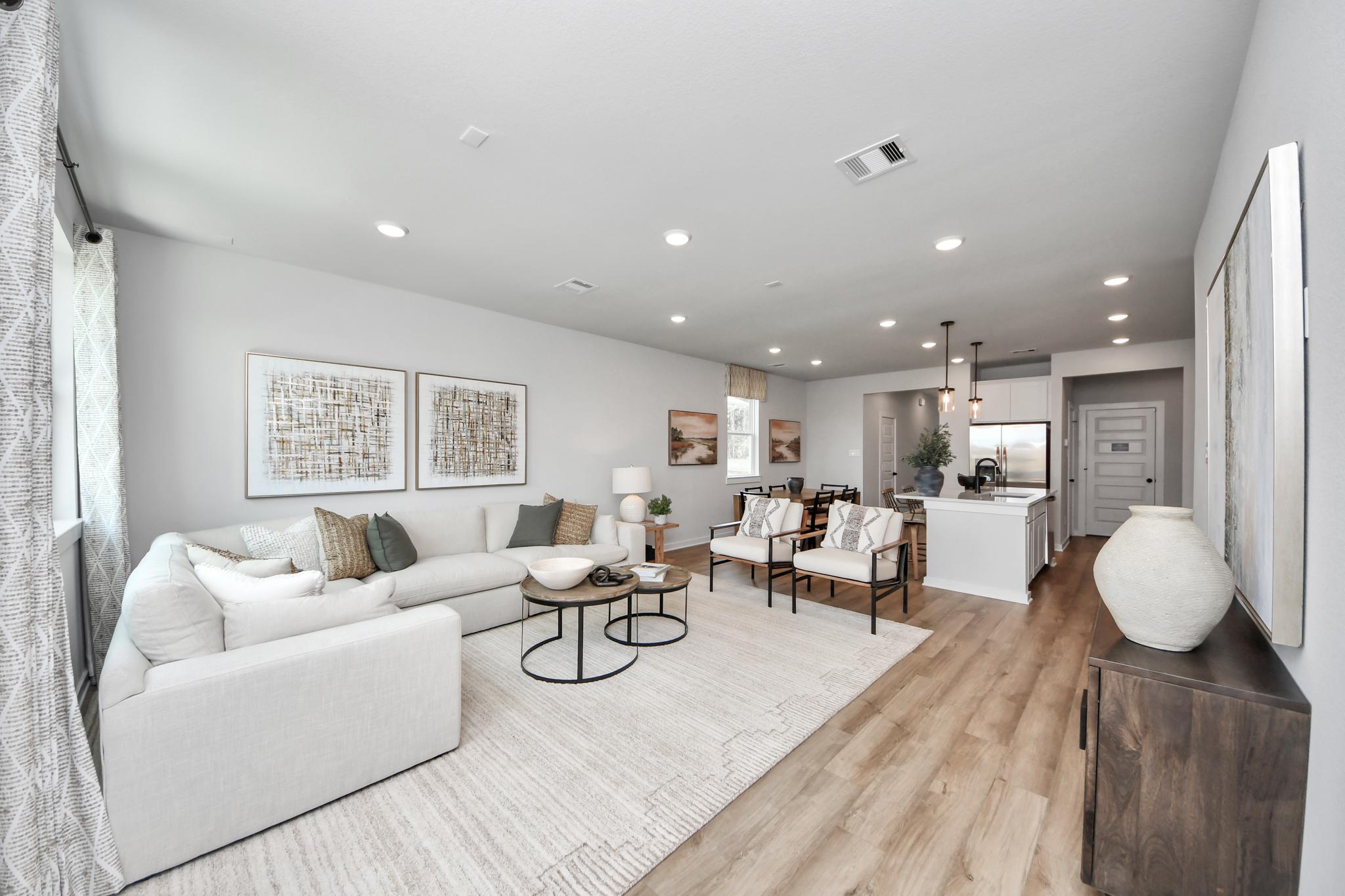 Open-concept living room at Robins Landing in Houston by Davidson Homes, featuring modern furniture and hardwood floors.