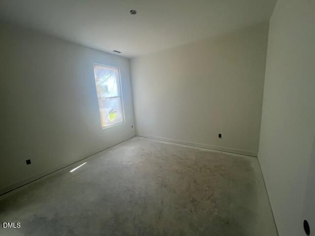 Empty bedroom with window and unfinished concrete floor in new Davidson Homes Magnolia II B plan, Retreat at North Main, Lillington NC