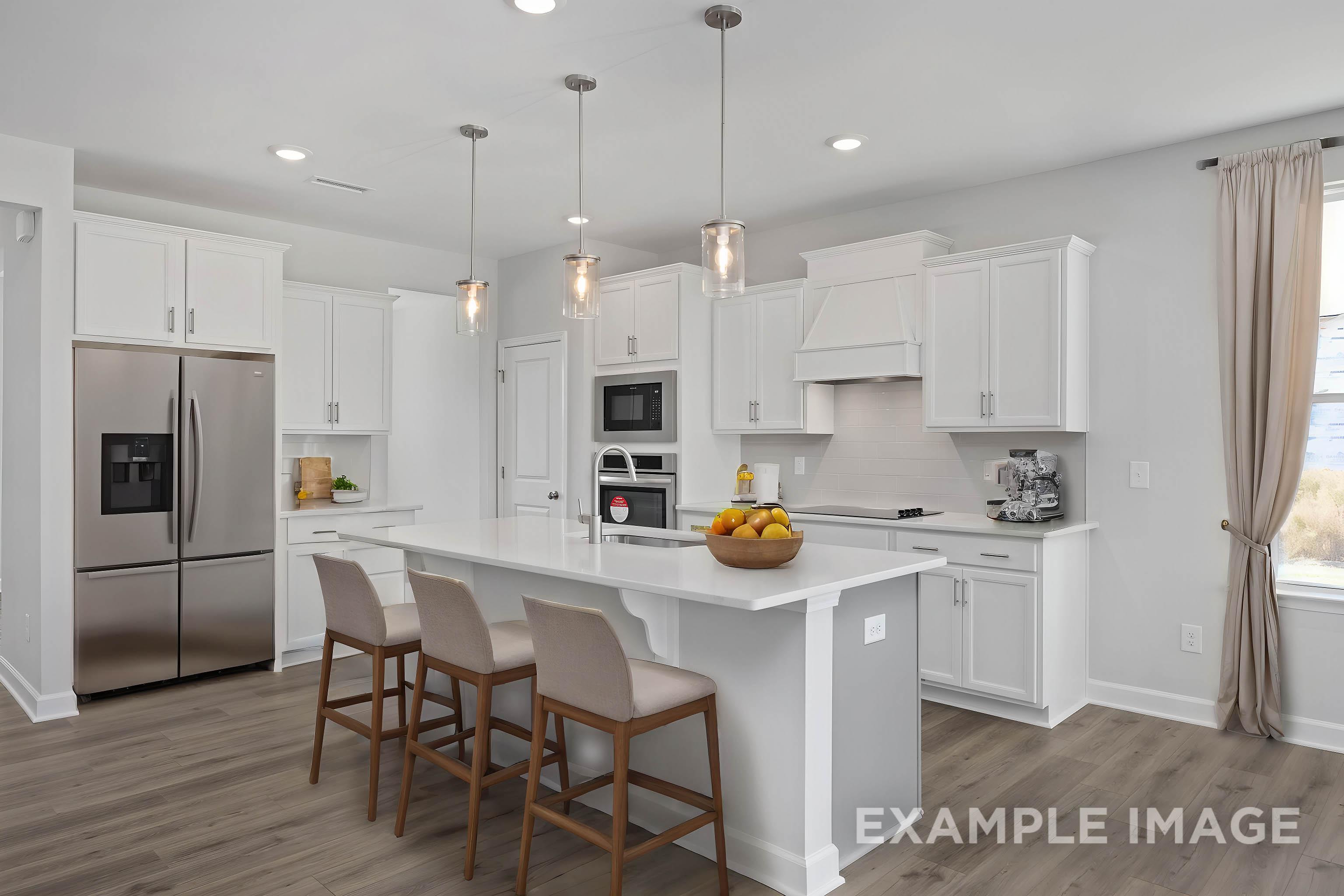 Modern white kitchen in The Ash home with large center island, stainless steel fridge, pendant lights, and bar stools