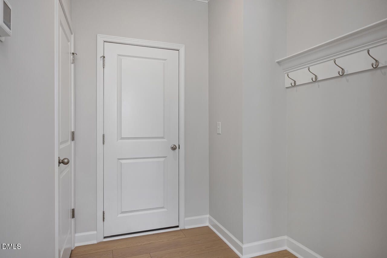 Mudroom entry with wall-mounted coat hooks and wood-style flooring in Davidson Homes The Mitchell at Camden Park, Knightdale.