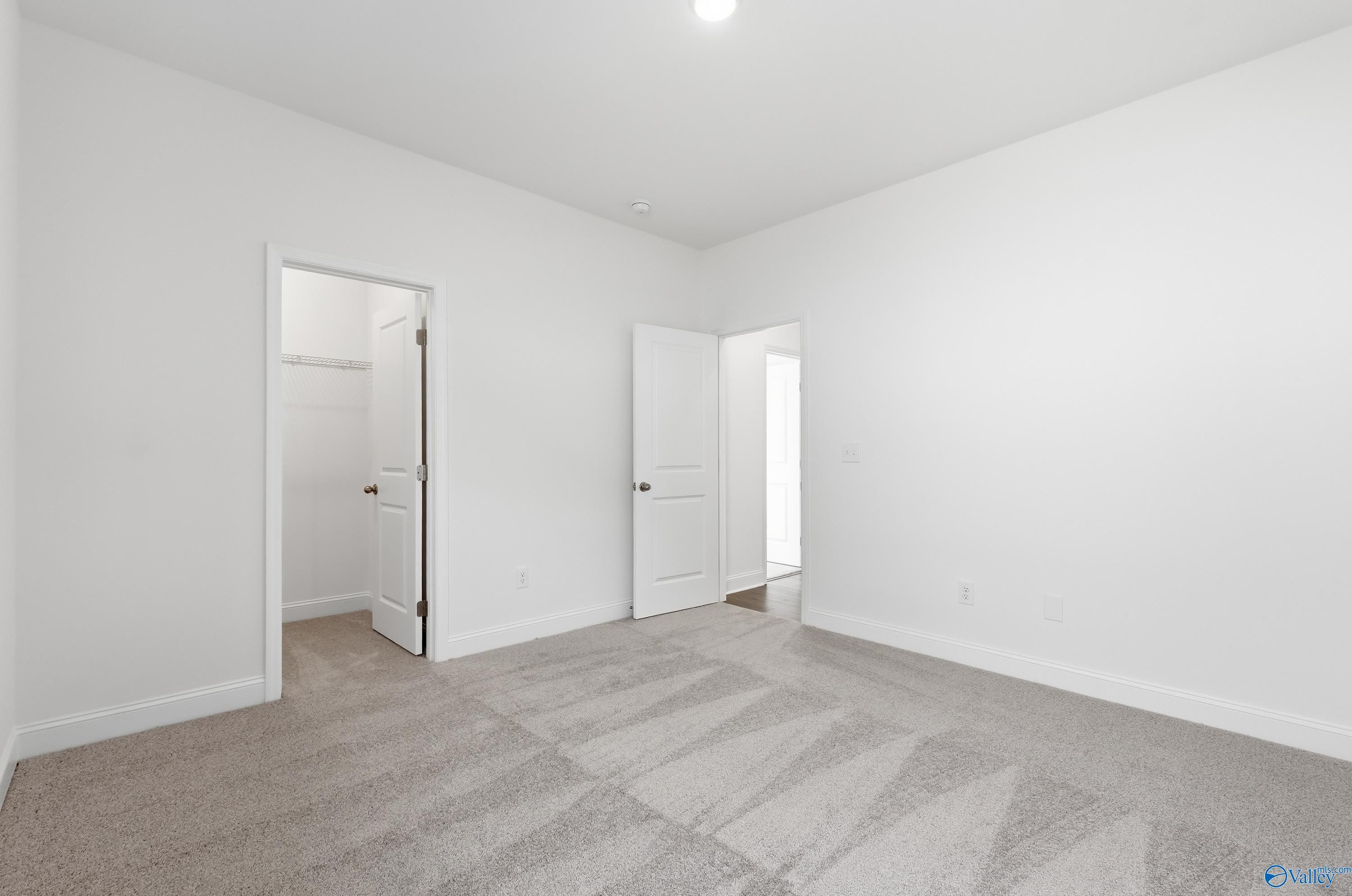 Bright secondary bedroom with open walk-in closet and bathroom door in 3BR Montgomery C home, Harvest AL