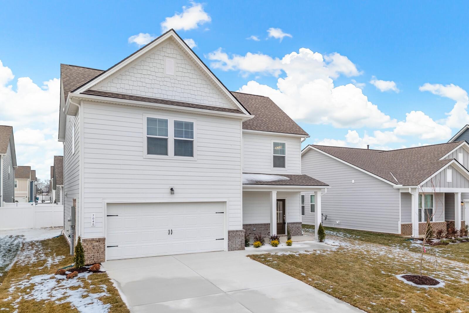 Two-story white home with 2-car garage, front porch, and light snow in yard, Sage Farms, White House, TN - Davidson Homes Gordon C