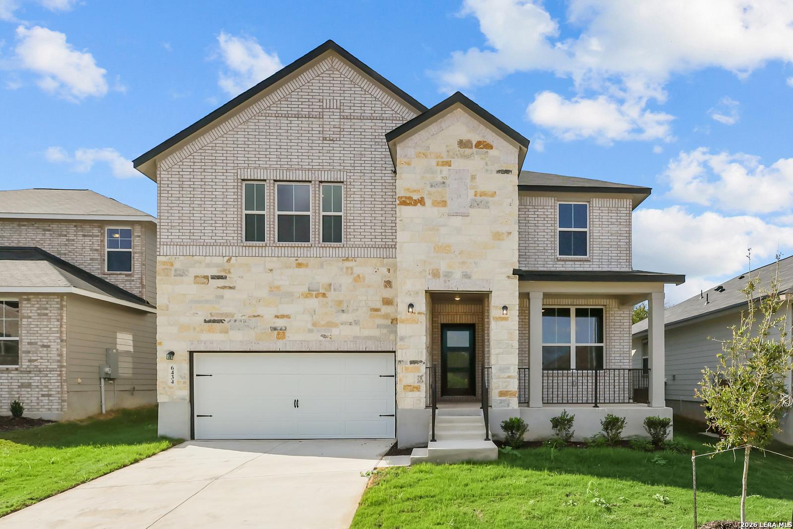 Two-story brick and stone exterior with 2-car garage and covered porch at Davidson Homes' The Sequoia C in Royal Crest, San Antonio