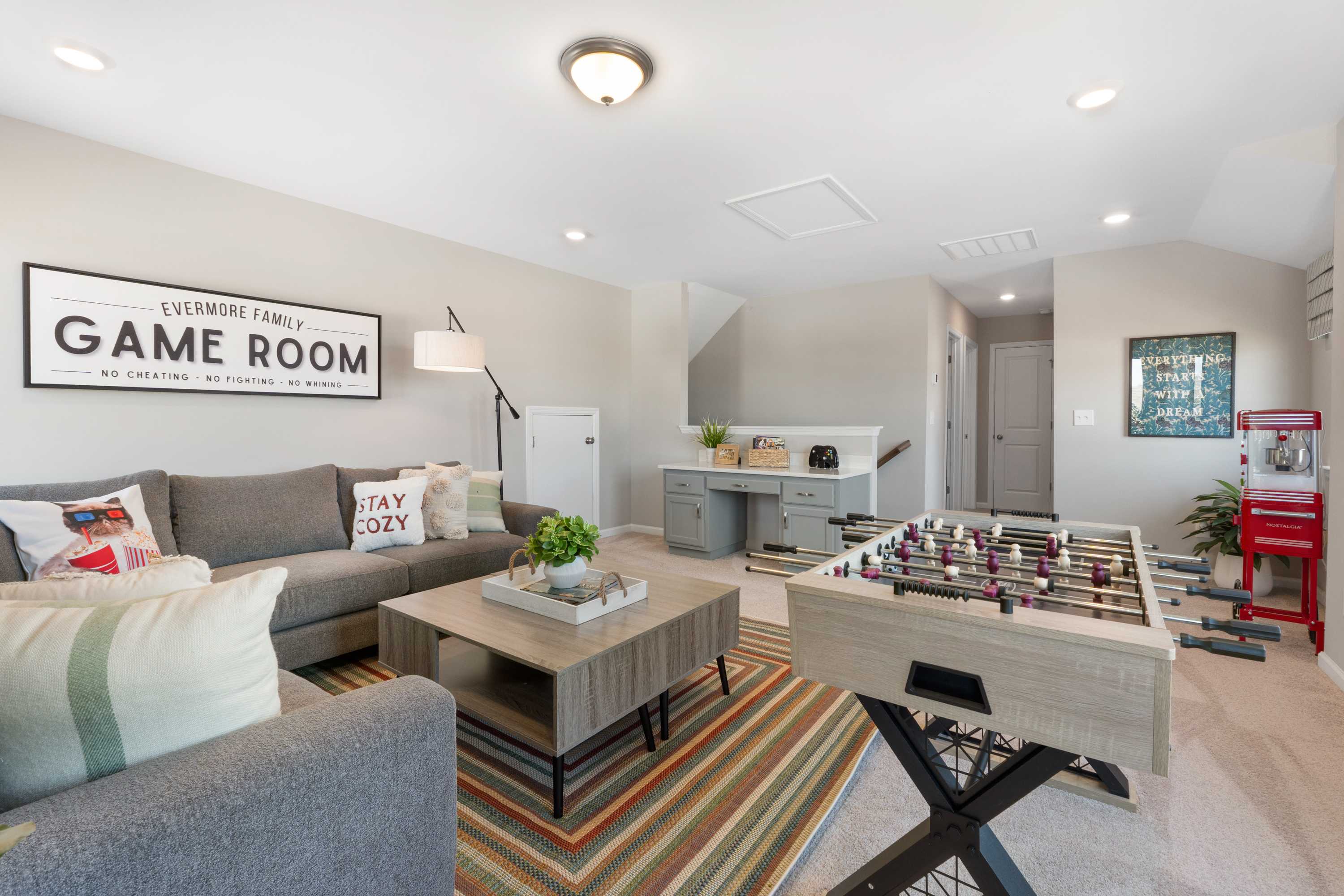 Cozy game room in Evergreen Mill Madison Alabama home by Evermore Homes featuring foosball table sectional sofa and desk