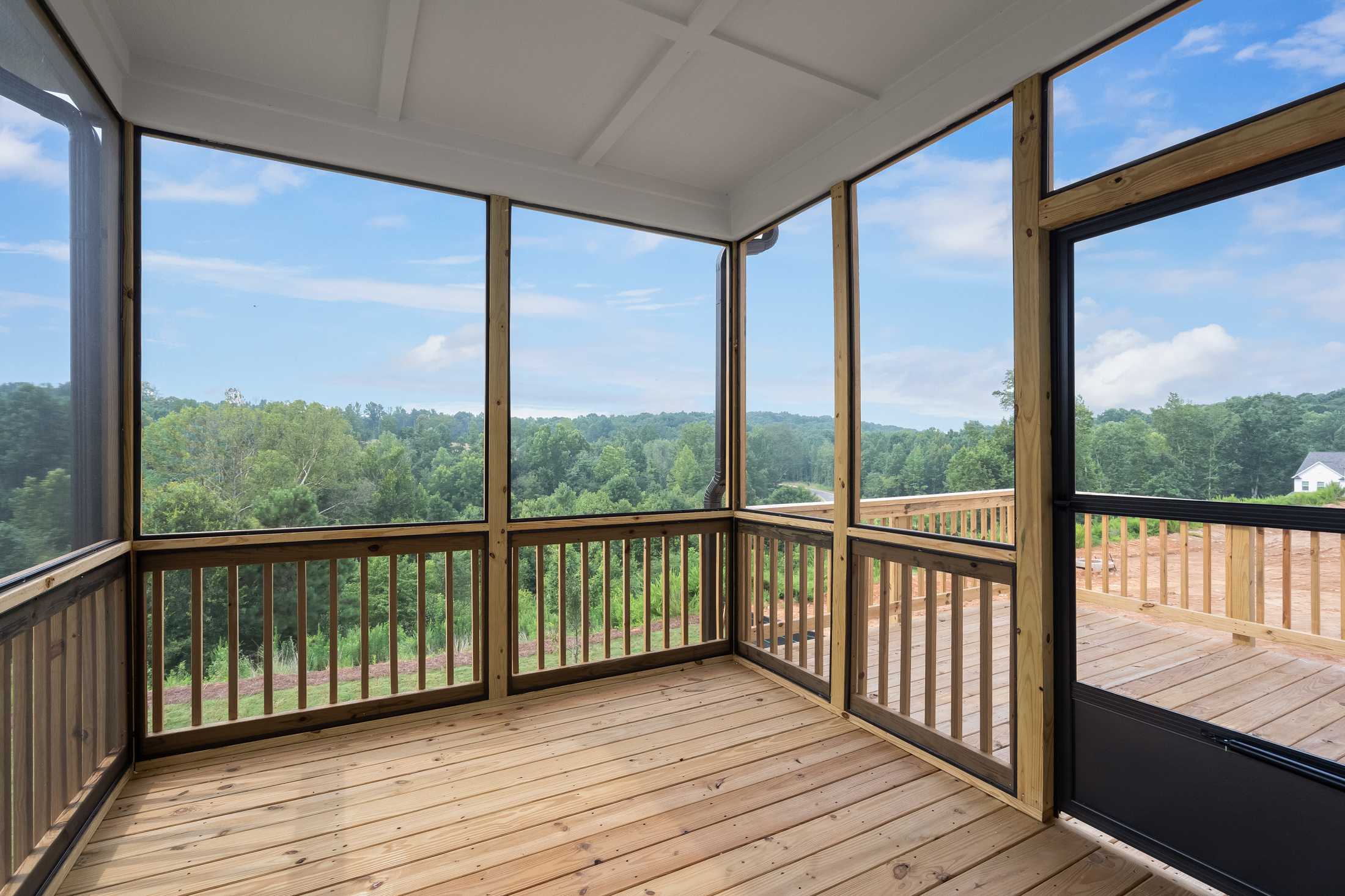 Screened porch at Reverie at East Lake in McDonough GA with wooden deck, screens and scenic wooded views