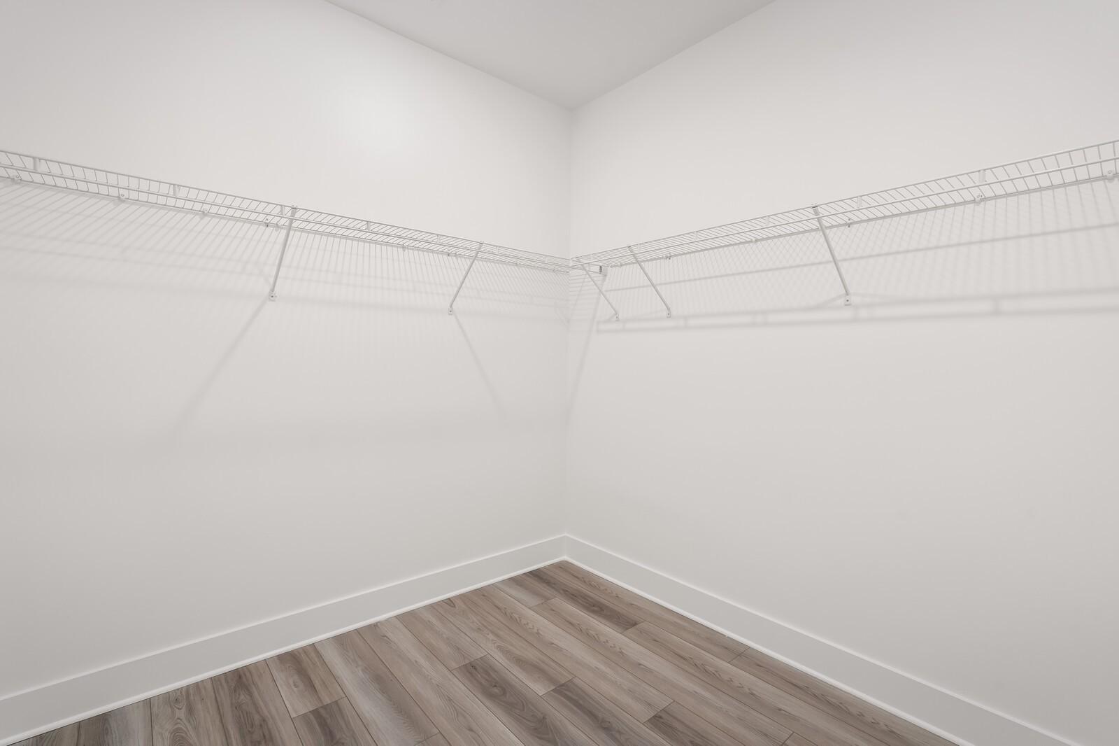 Spacious walk-in closet with wire shelving, white walls, and hardwood floors in Davidson Homes The Ash C, Mt. Juliet, Tennessee