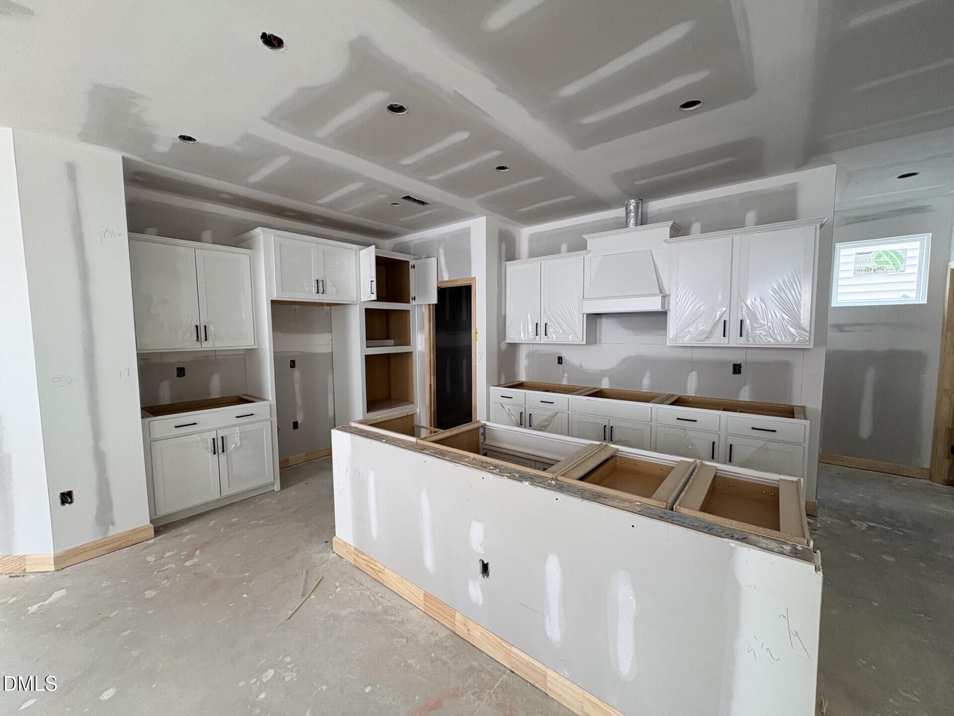New kitchen construction with white cabinets and island in The Adalynn A floor plan, Woodland Crossing, Zebulon, NC.