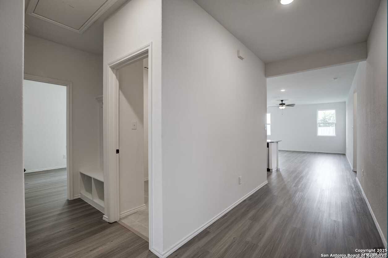 Bright hallway with built-in bench, white walls, and open living space in Davidson Homes The Daphne H, Seguin, Texas