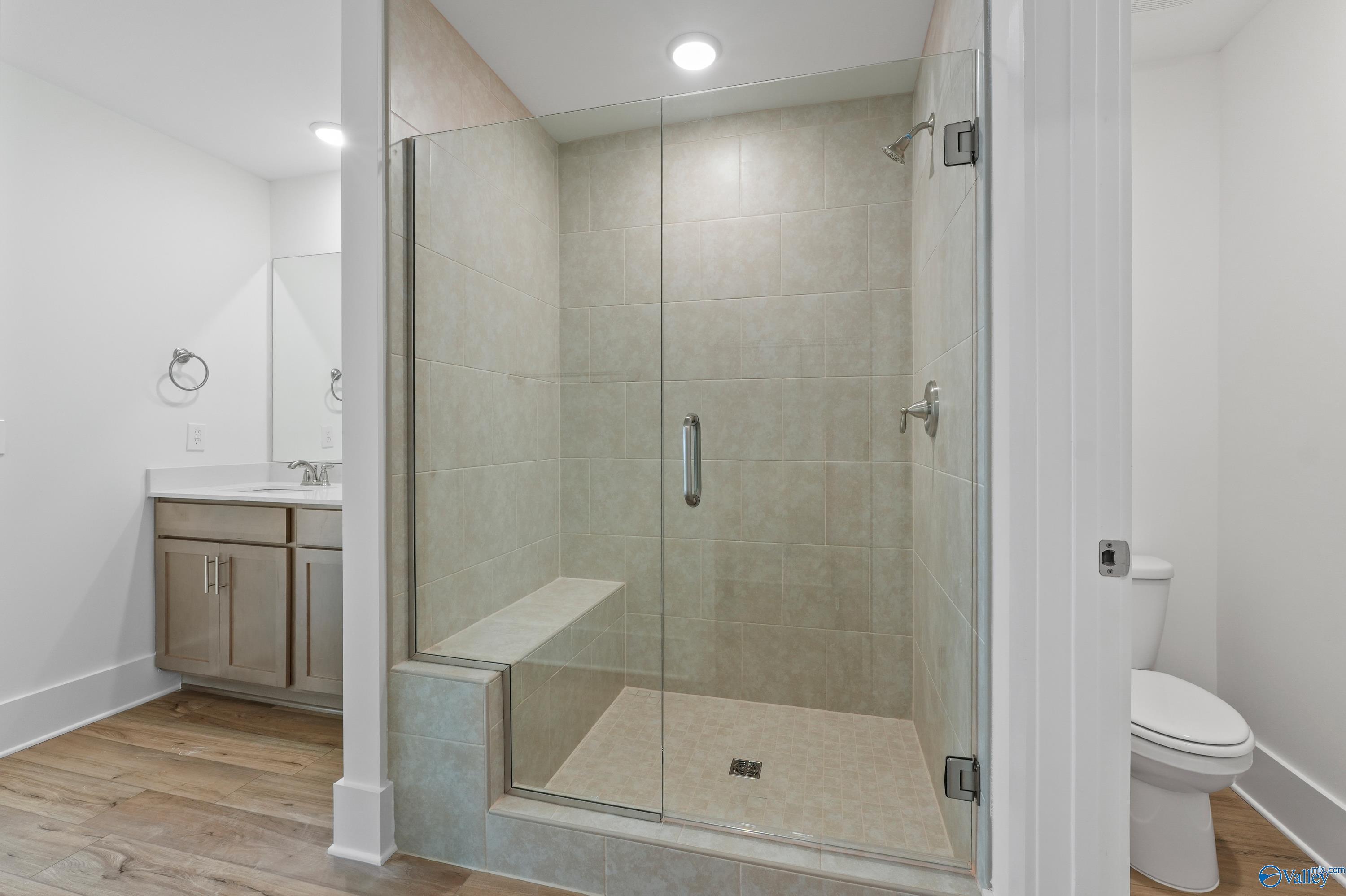 Modern master bathroom featuring glass walk-in shower with bench, double vanity in The Daphne C by Davidson Homes, Arab, Alabama