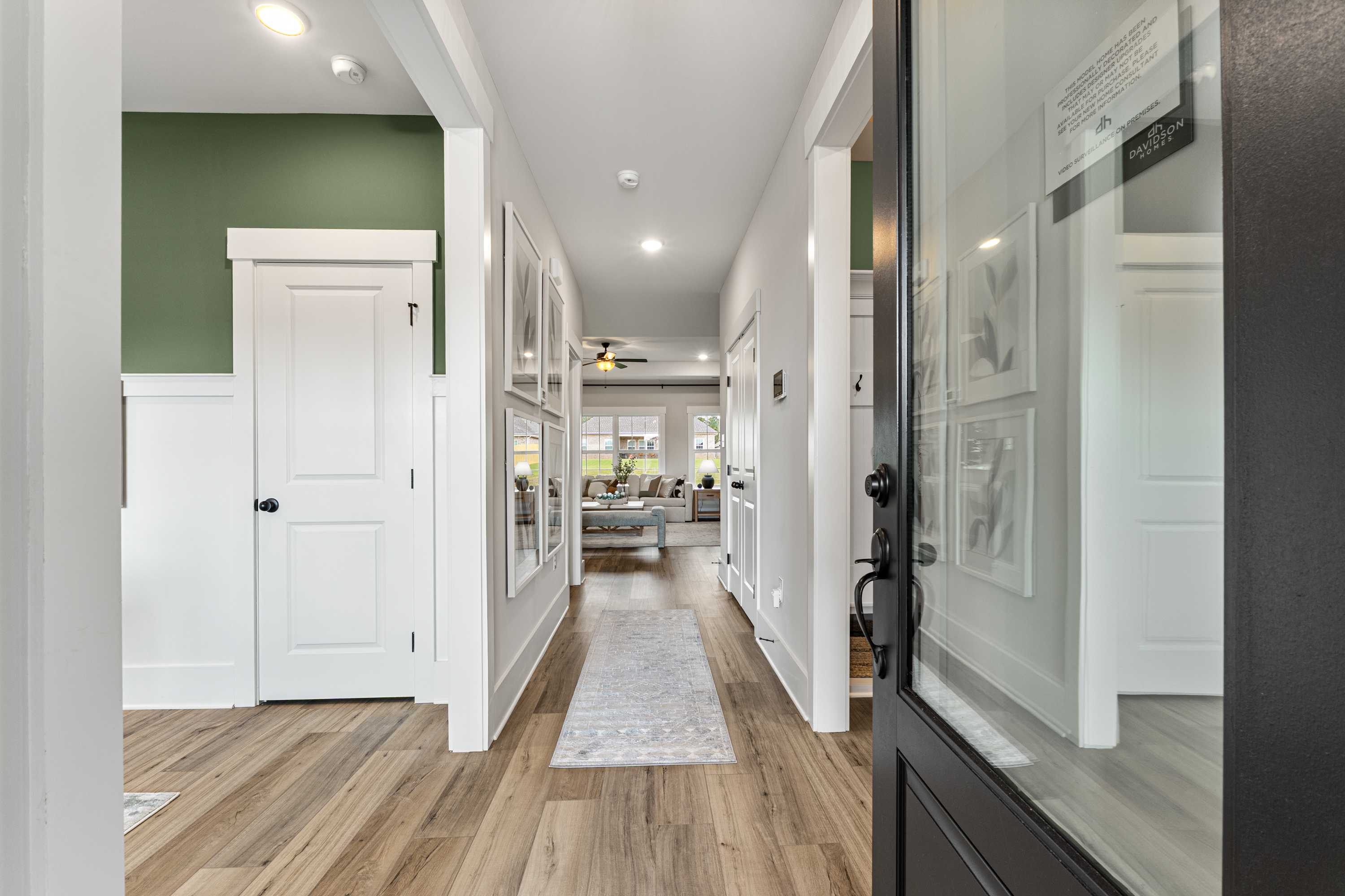 Spacious hallway interior at River Road Estates in Decatur Alabama with hardwood floors white doors green accent wall