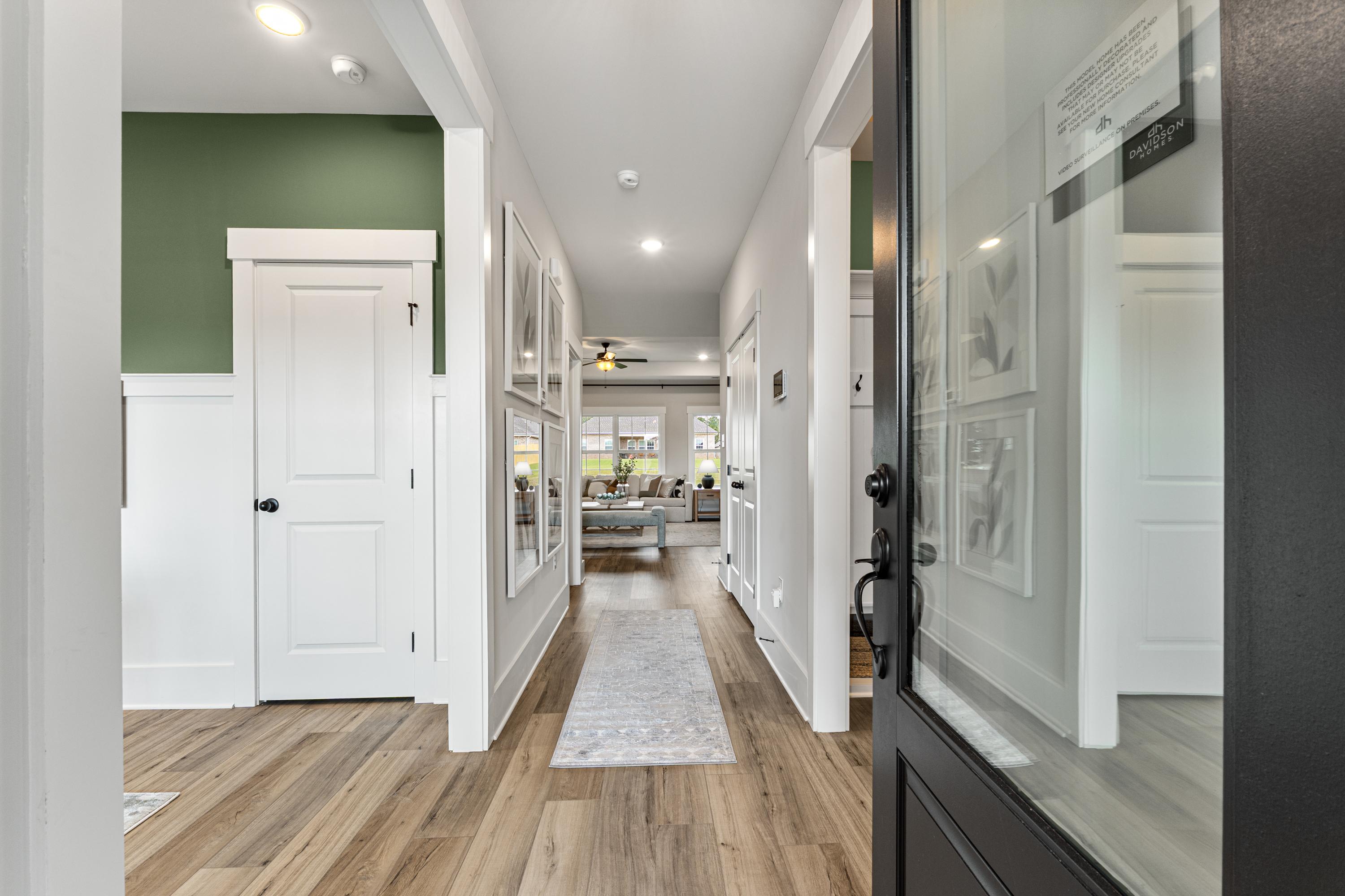 Spacious hallway interior at River Road Estates in Decatur Alabama with hardwood floors white doors green accent wall