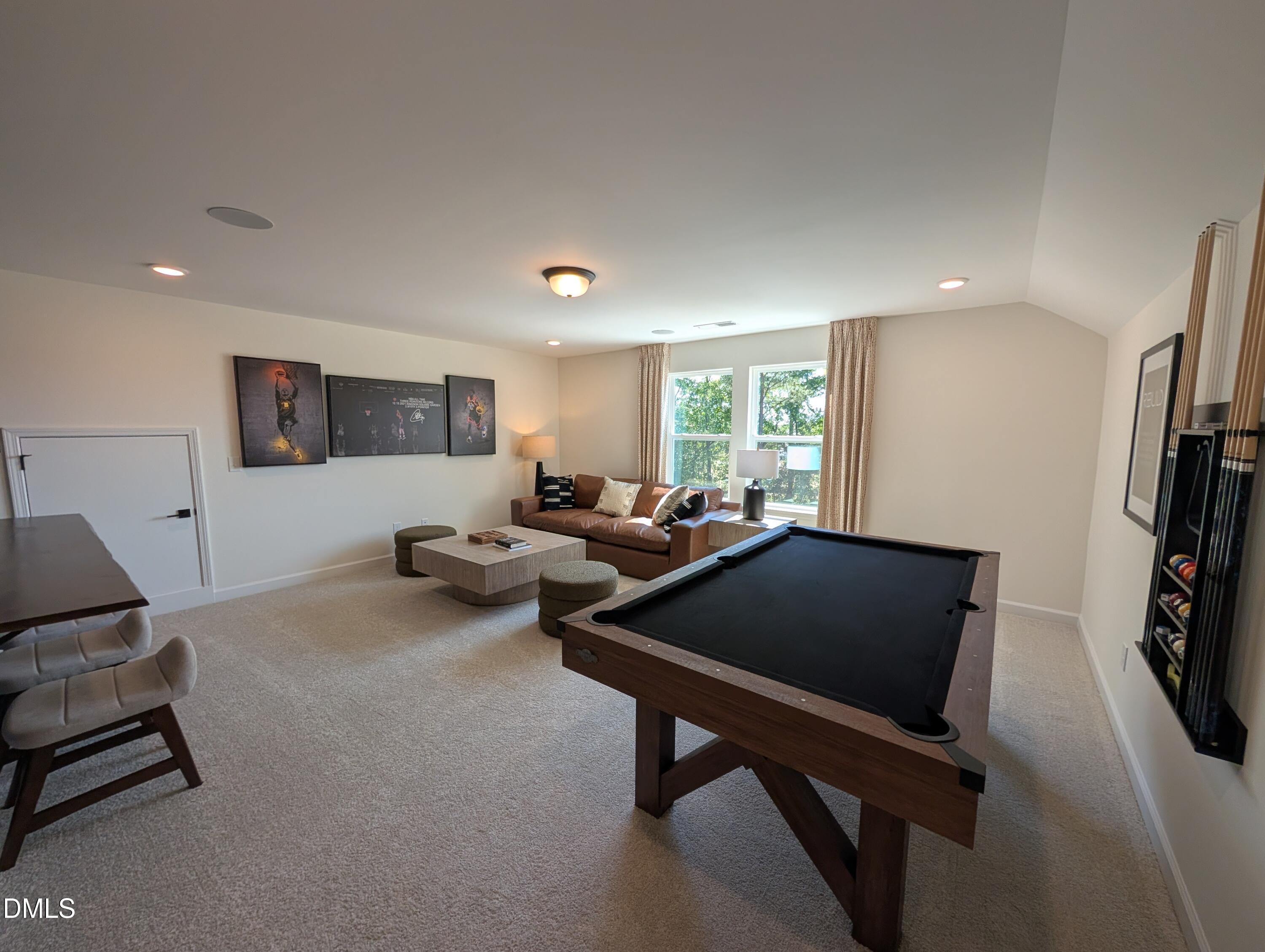 Spacious game room with pool table and lounge area in The Aspen B floor plan at Wendell Ridge, Wendell, North Carolina.