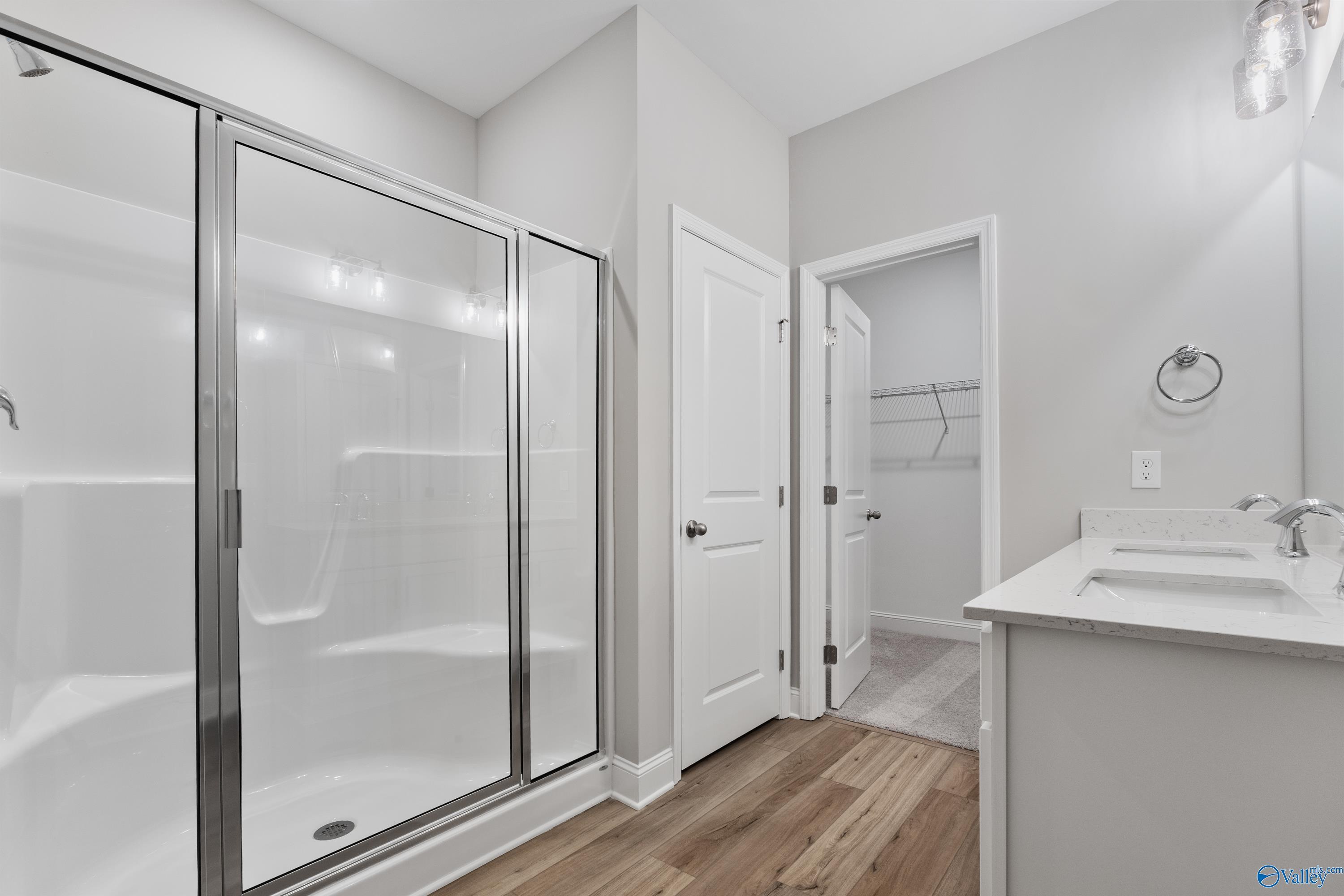 Elegant master bathroom with frameless glass shower and white vanity in Davidson Homes The Franklin C, Spragins Cove, Huntsville, AL