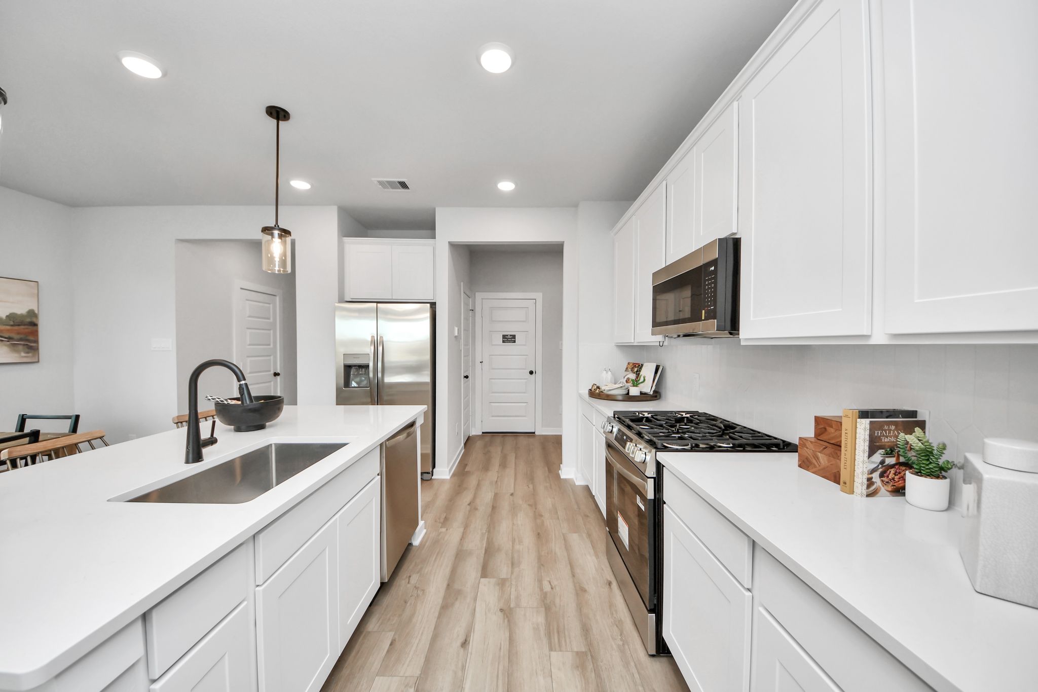 Modern kitchen at Robins Landing in Houston with white cabinetry, stainless appliances, and a large center island.