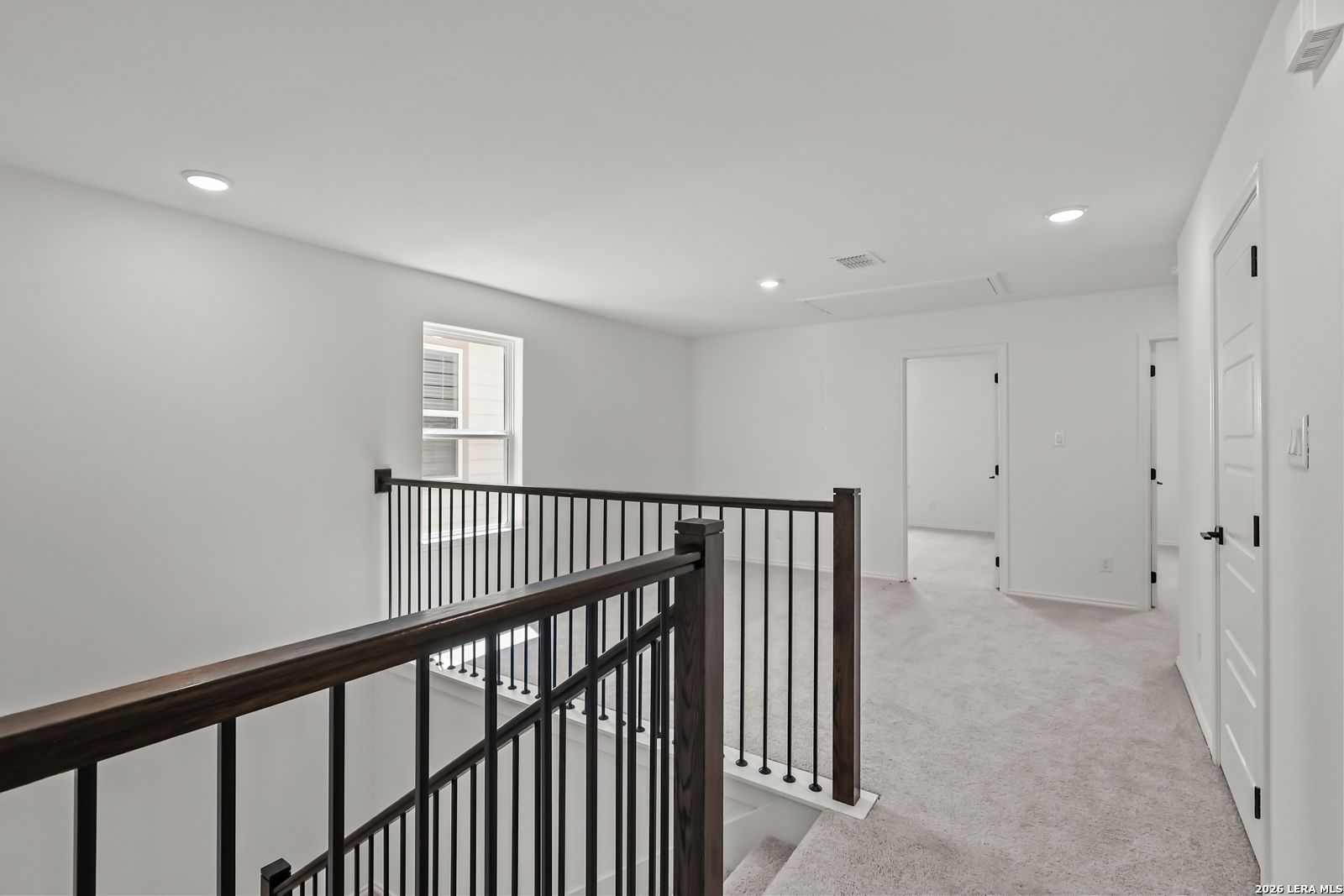 Spacious upstairs loft area with iron railing in The Florence B floor plan at Meadows at Oak Creek, San Antonio, Texas.