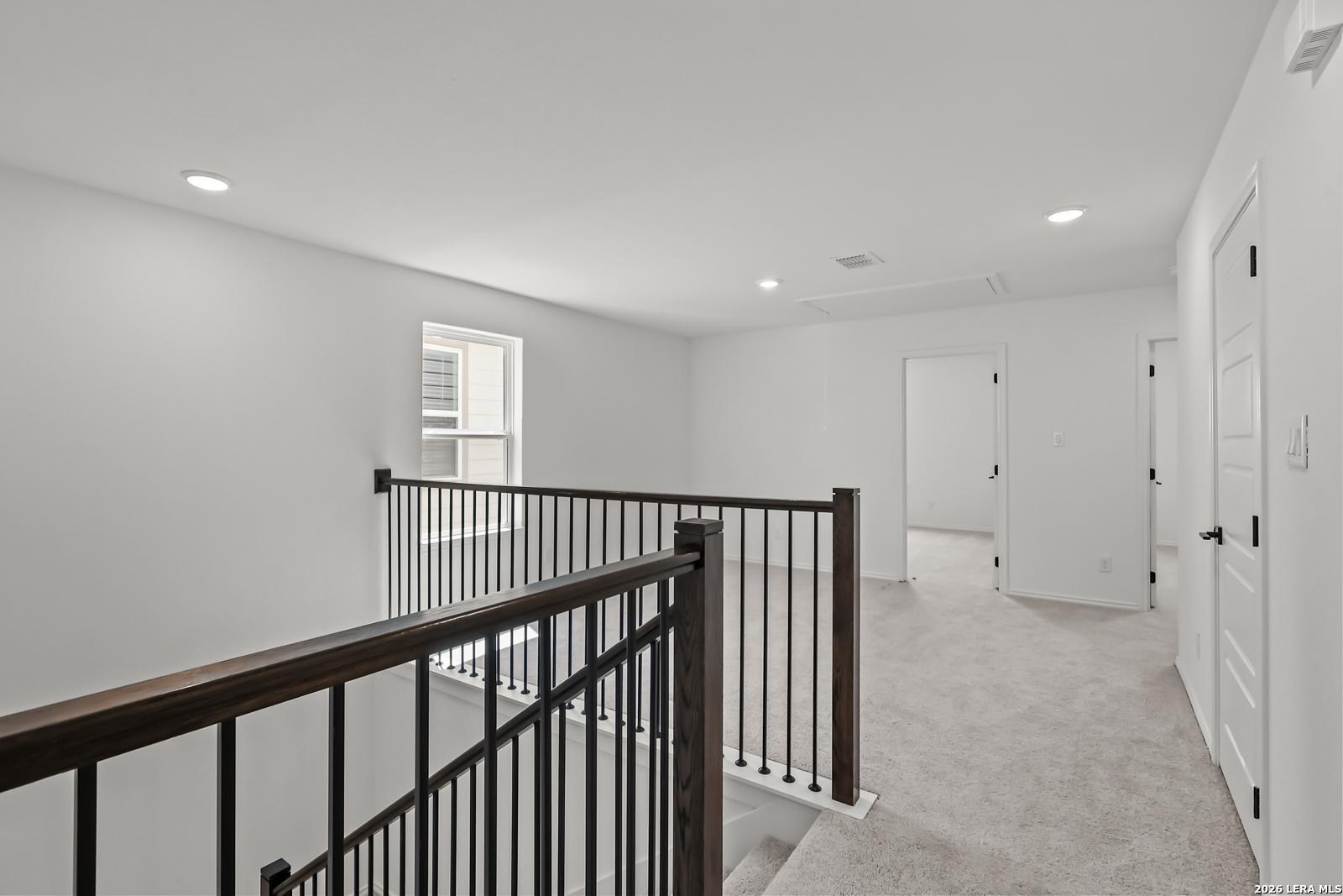 Spacious upstairs loft area with iron railing in The Florence B floor plan at Meadows at Oak Creek, San Antonio, Texas.