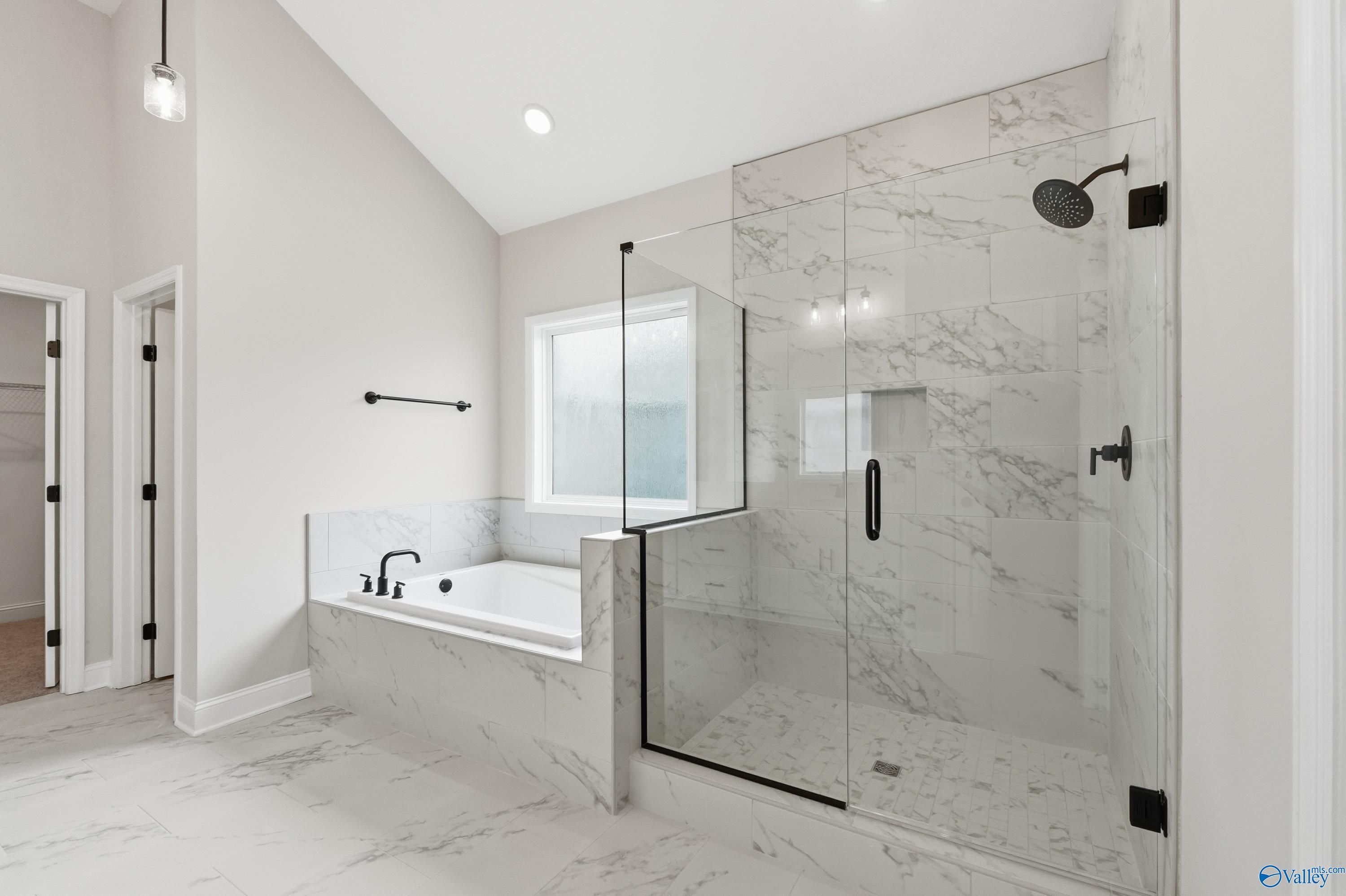 Luxurious master bathroom with freestanding tub, marble shower, and glass enclosure in Davidson Homes The Finleigh, Meridianville, Alabama