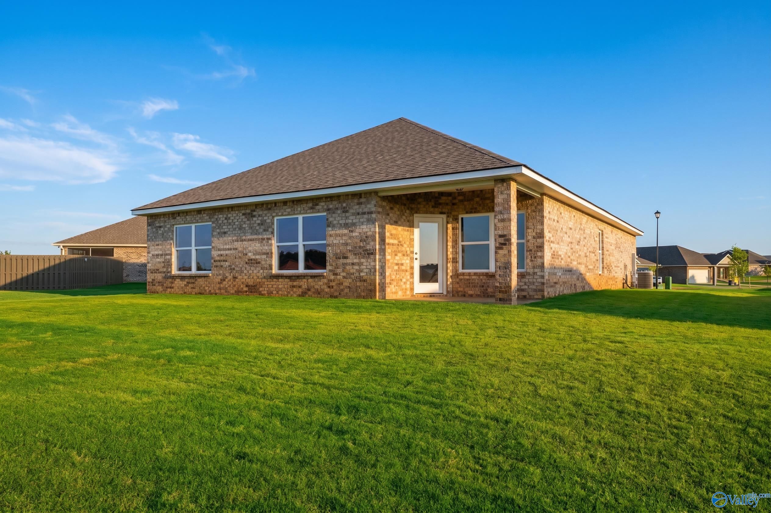 Brick exterior and backyard of The Daphne D floor plan by Davidson Homes in Creekside, Harvest, Alabama.