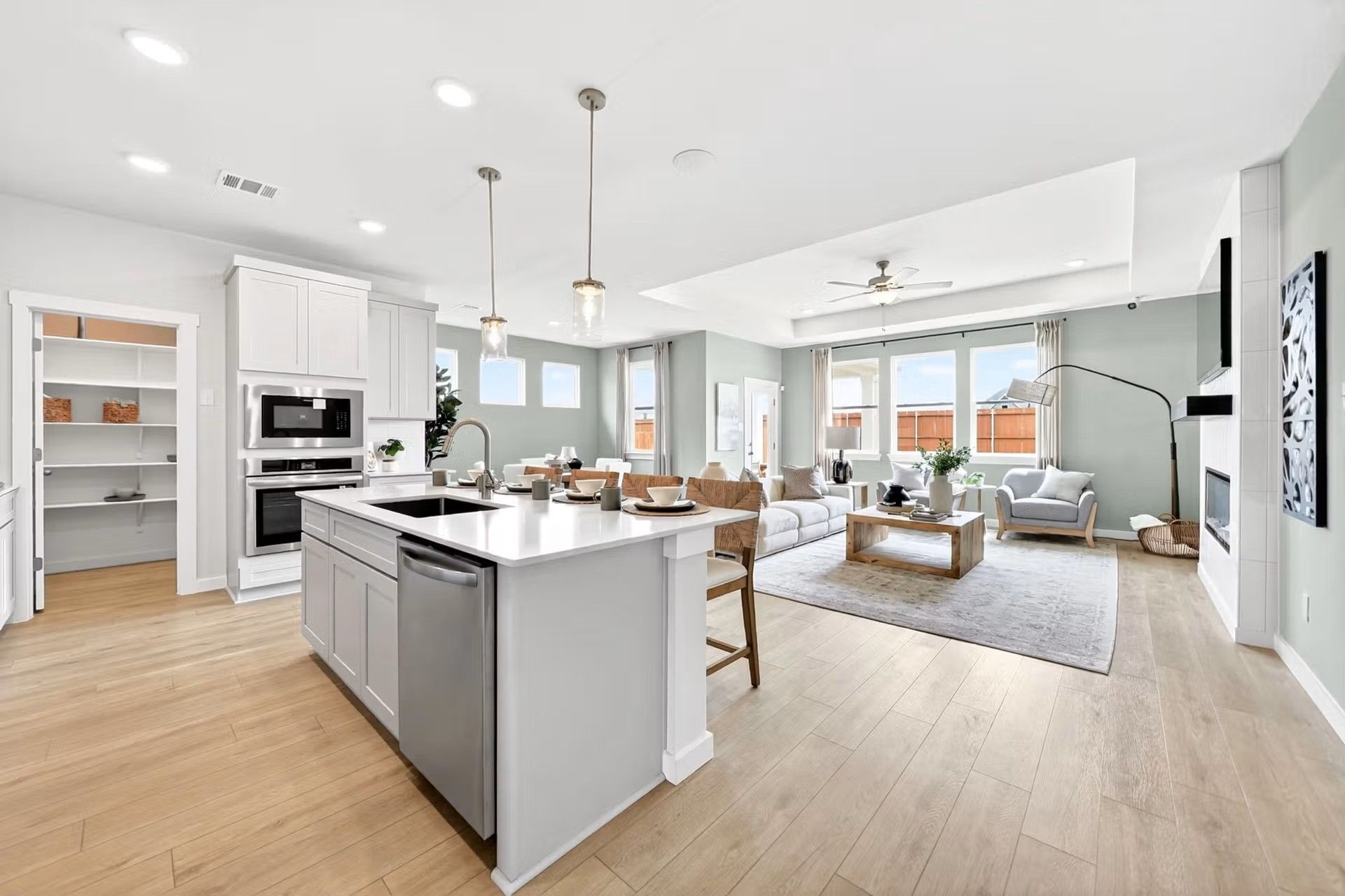Open-concept kitchen and living area with island in The Laurel I floor plan by Davidson Homes in Heartland, Texas.