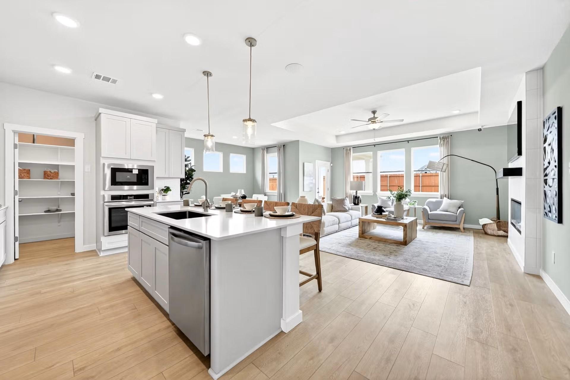 Open-concept kitchen and living area with island in The Laurel I floor plan by Davidson Homes in Heartland, Texas.