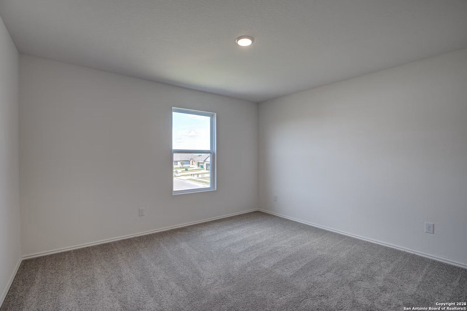 Bright secondary bedroom with white walls, gray carpet, and window view in Davidson Homes The Douglas B, Seguin, Texas