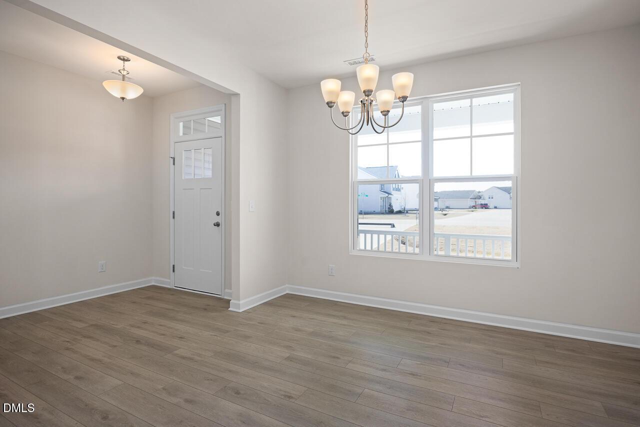 Bright dining room with chandelier, large windows, and hardwood floors in Davidson Homes The Ash B, Lillington, NC