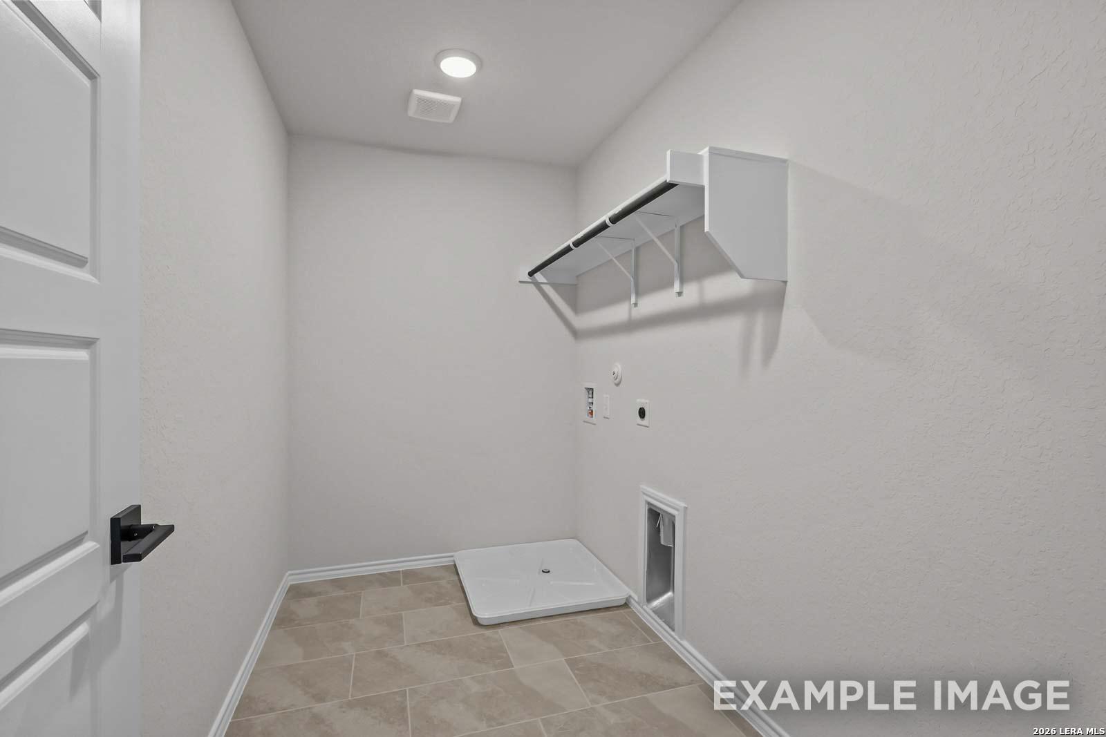 Dedicated laundry room with tile flooring and storage shelving in The Florence D floor plan by Davidson Homes.