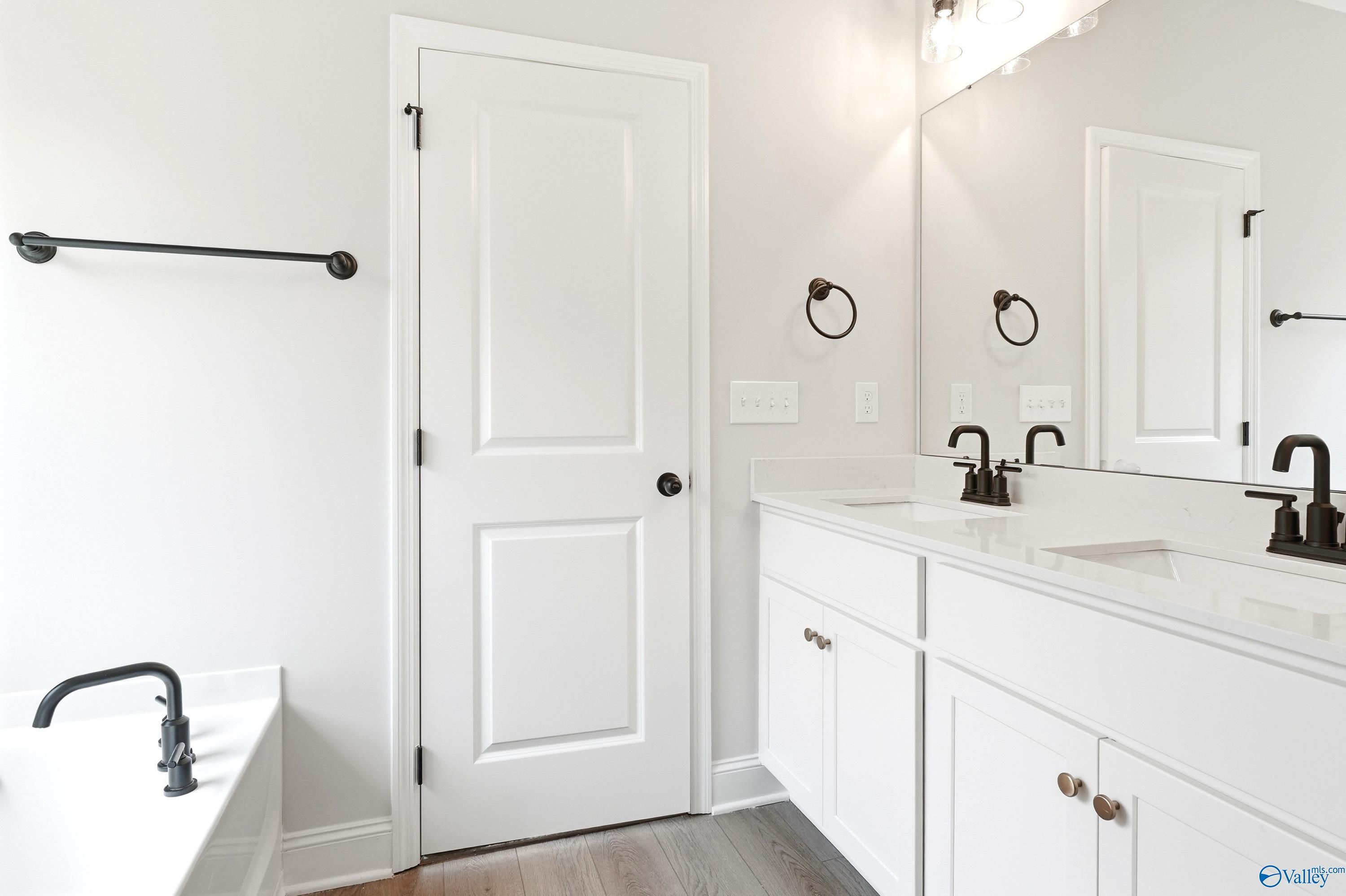 Modern bathroom with double vanity and soaking tub in The Daphne floor plan at Lynn Meadows, Meridianville, Alabama.