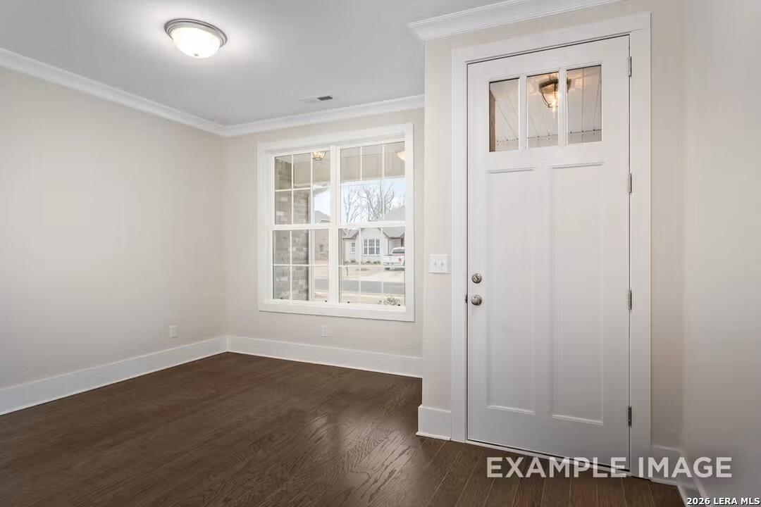 Bright entry foyer with hardwood floors, large window view, and glass-paneled door in Davidson Homes The Rockford F, Castroville TX