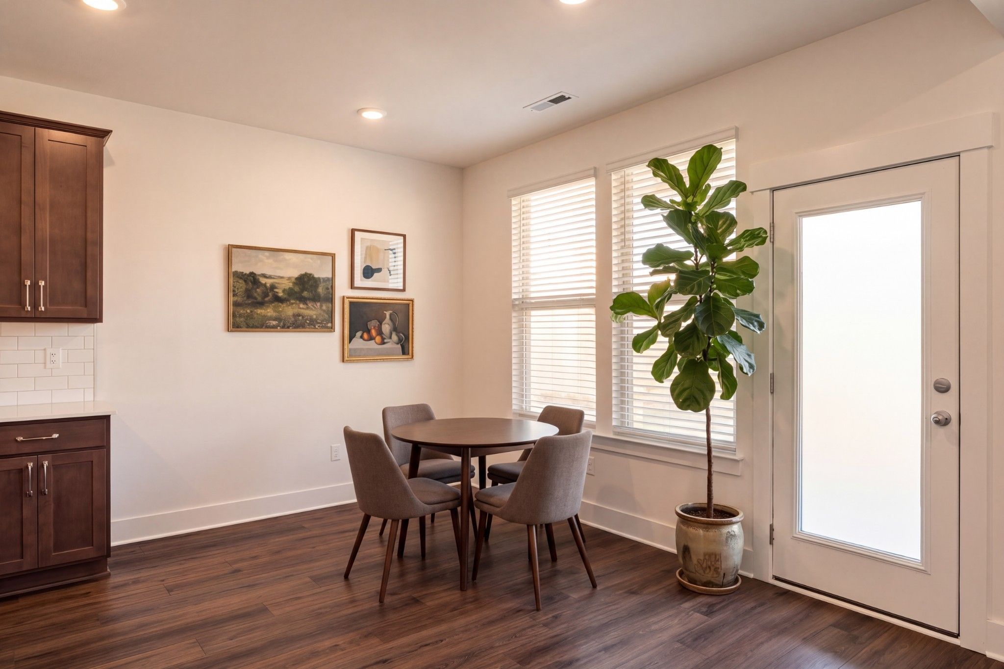 Bright breakfast nook with hardwood floors, round dining table, and fiddle leaf fig in Davidson Homes Willow C, Gallatin TN